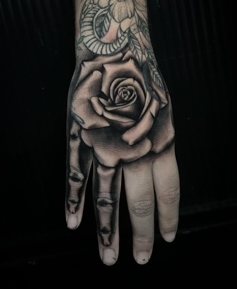 Rose tattoo idea on hand in blackwork tattoo style
