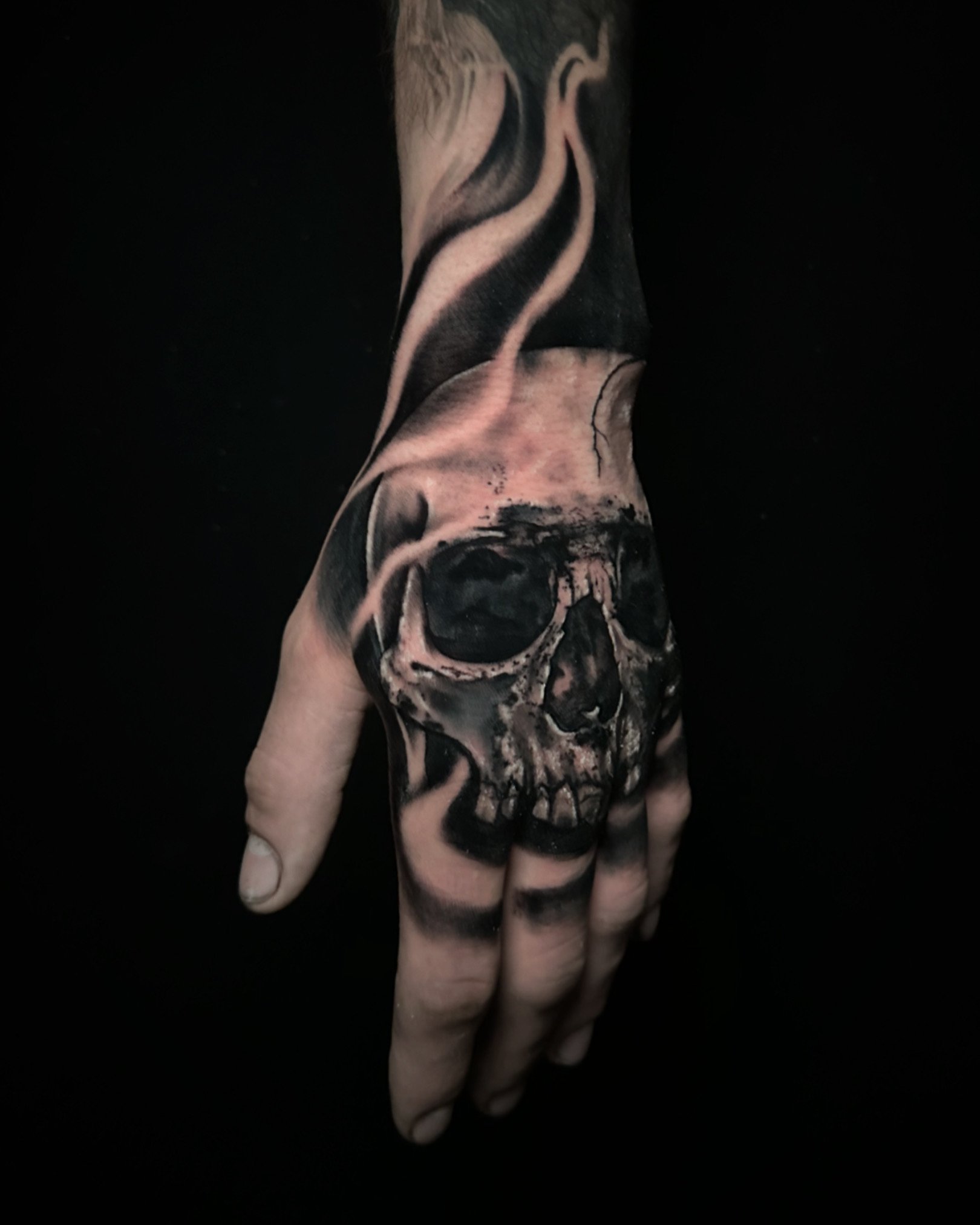 Skull Tattoo idea on hand in blackwork tattoo style