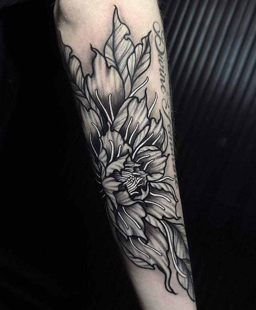 Flower tattoo idea on arm in blackwork tattoo style