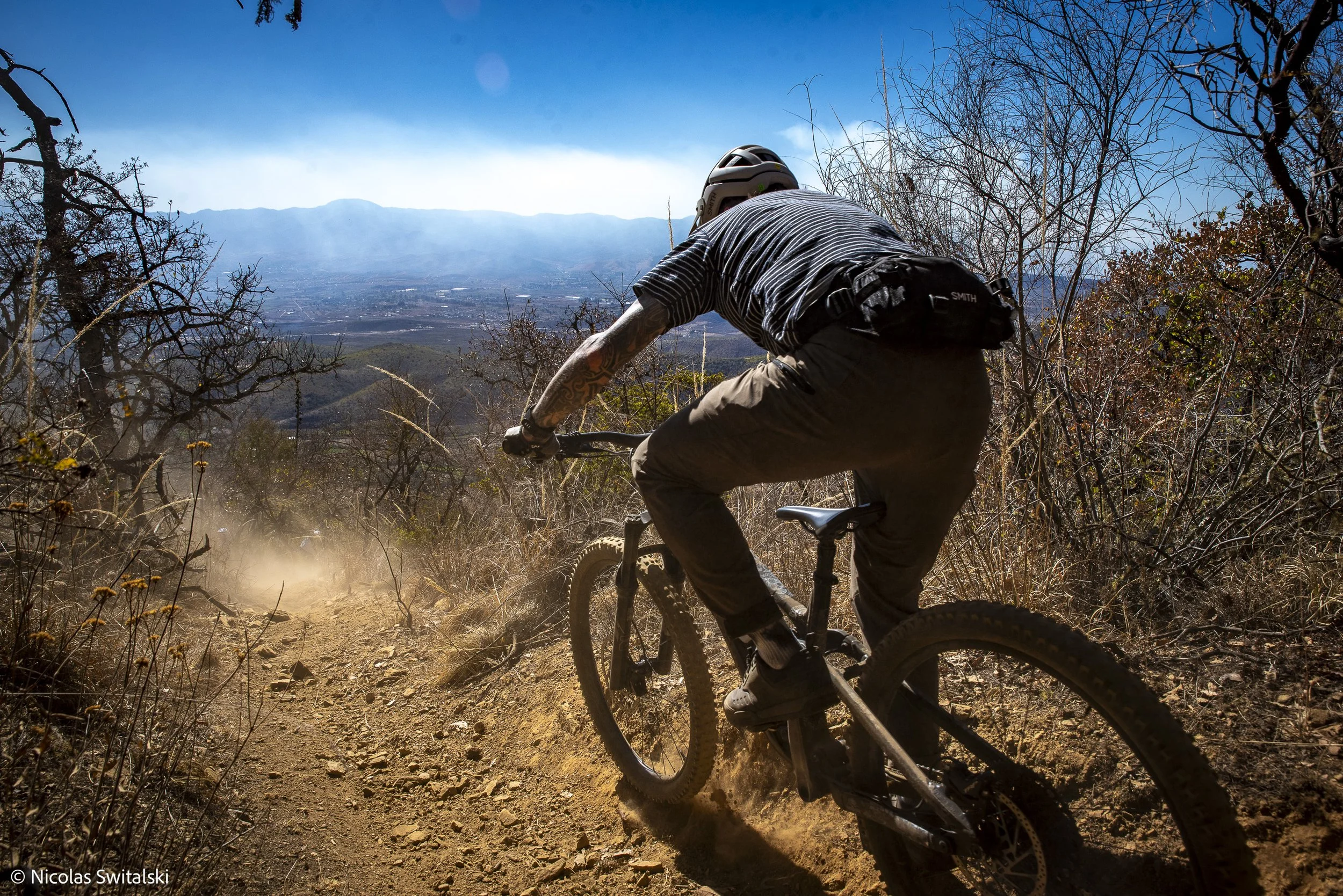 Back take of an enduro mountain bike rider descending a technical trail in the Sierra Norte of Oaxaca Mexico