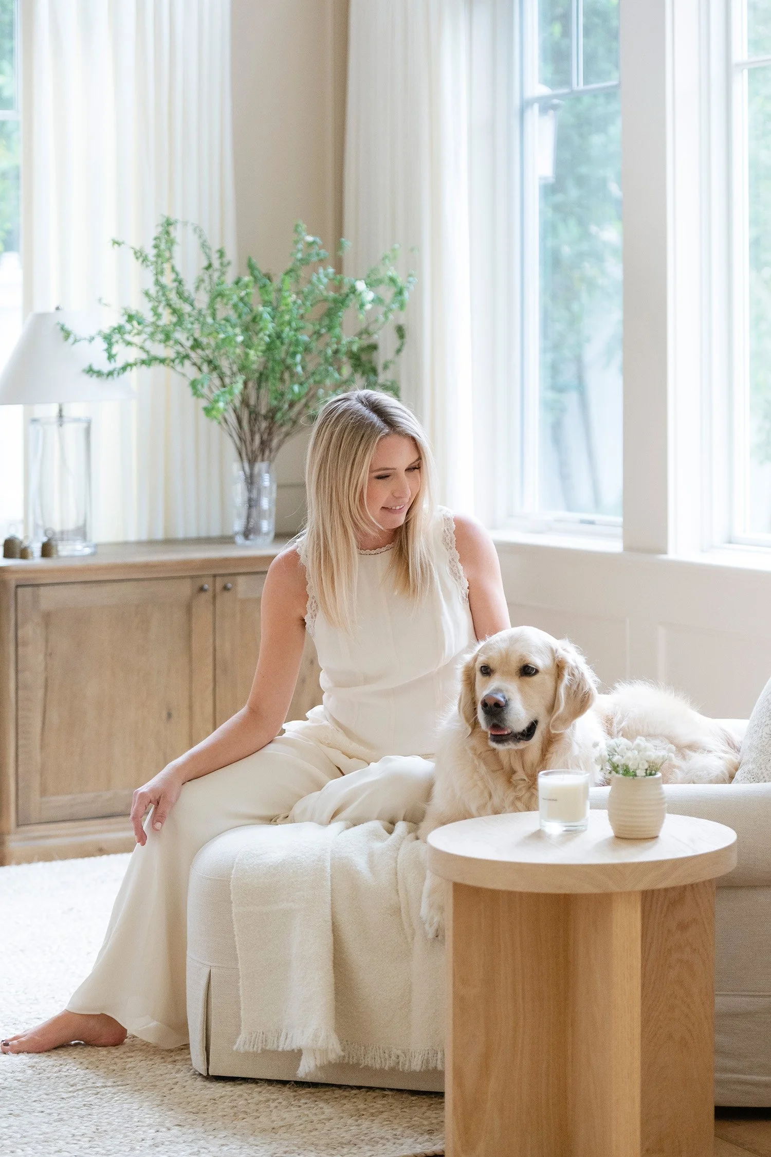 Orange County pet-friendly brand photographer captures lifestyle brand portrait of woman with golden retriever in bright living room