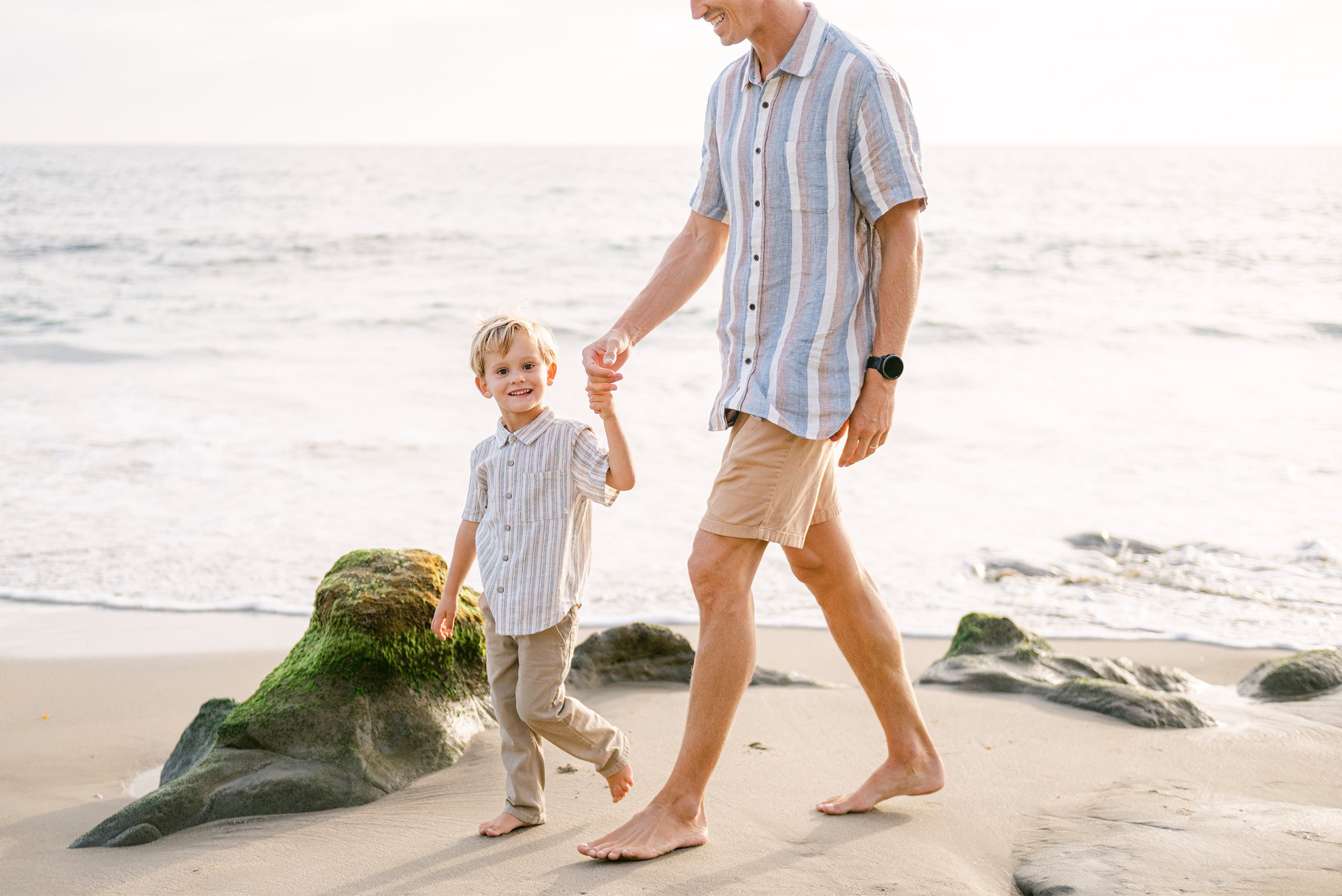 Orange County family photographer captures candid father-son walk along the shoreline in Laguna Beach