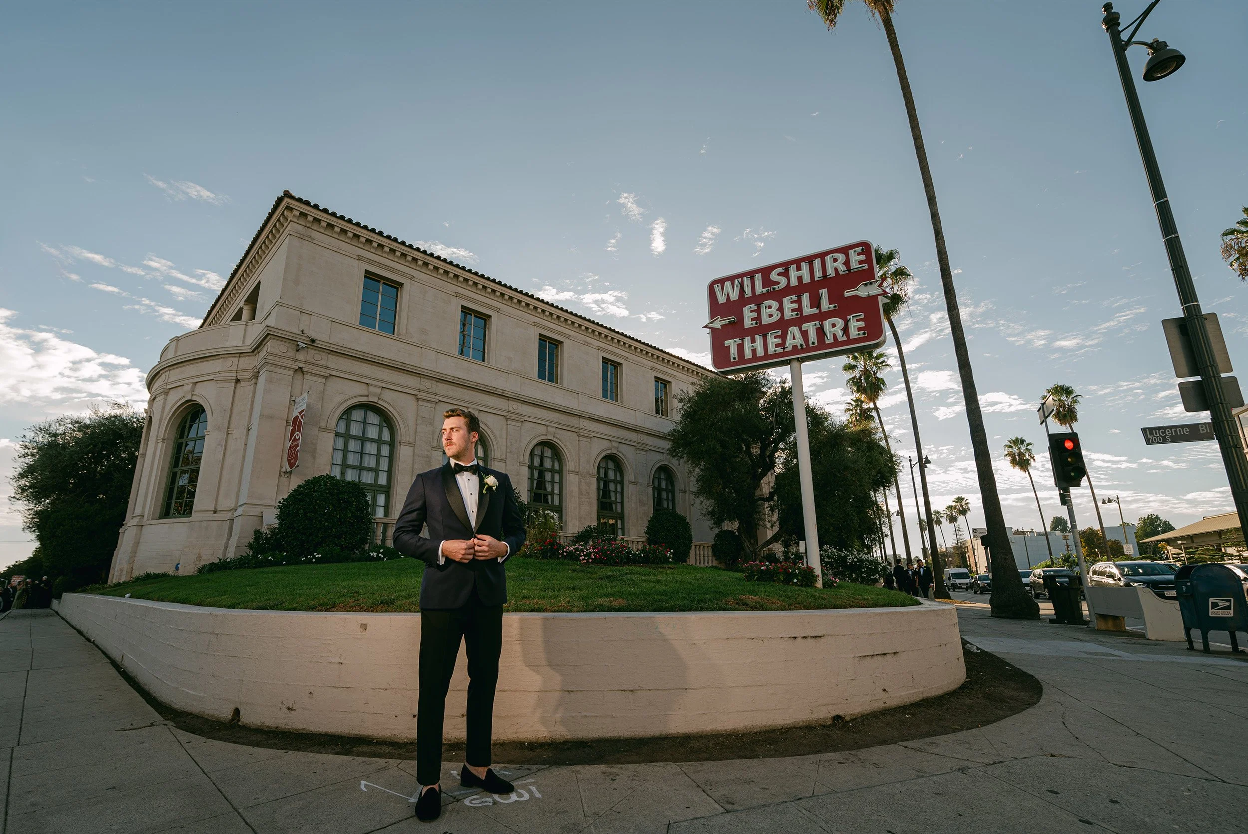 Los Angeles wedding photographer captures groom standing outside historic Wilshire Ebell Theatre venue at golden hour