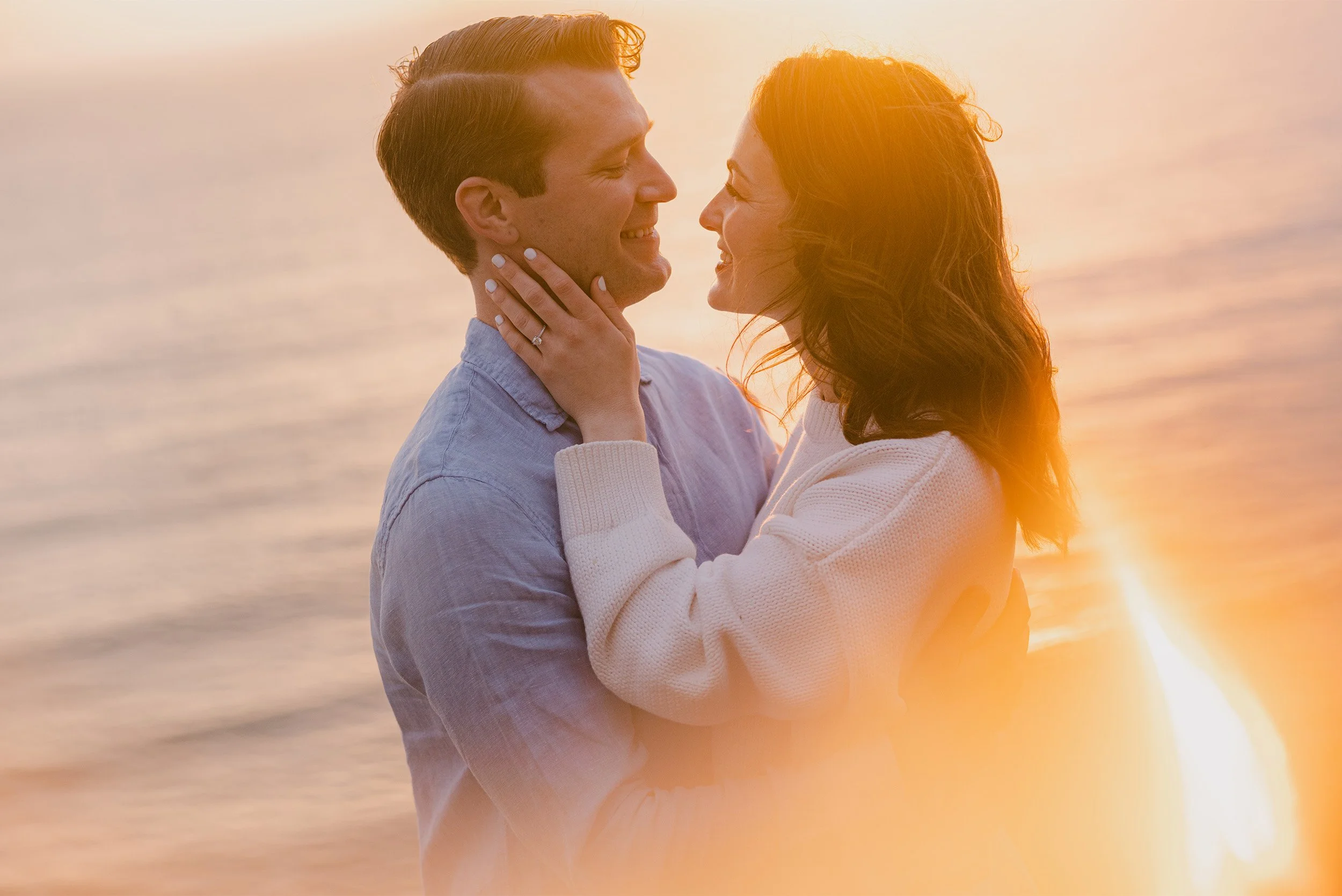 Santa Barbara engagement photographer captures couple laughing together in golden sunset backlight