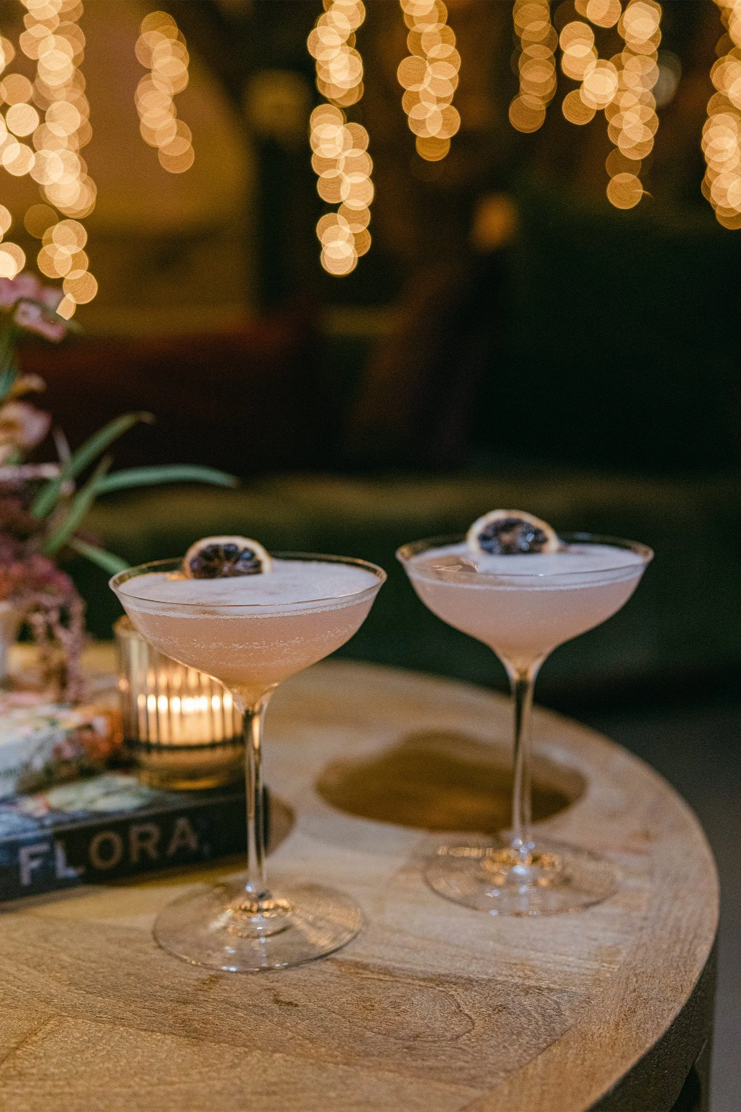 Orange County wedding photographer captures elegant wedding signature cocktails with citrus garnish under twinkling string lights at reception, The Swanner House Wedding Venue in San Juan Capistrano
