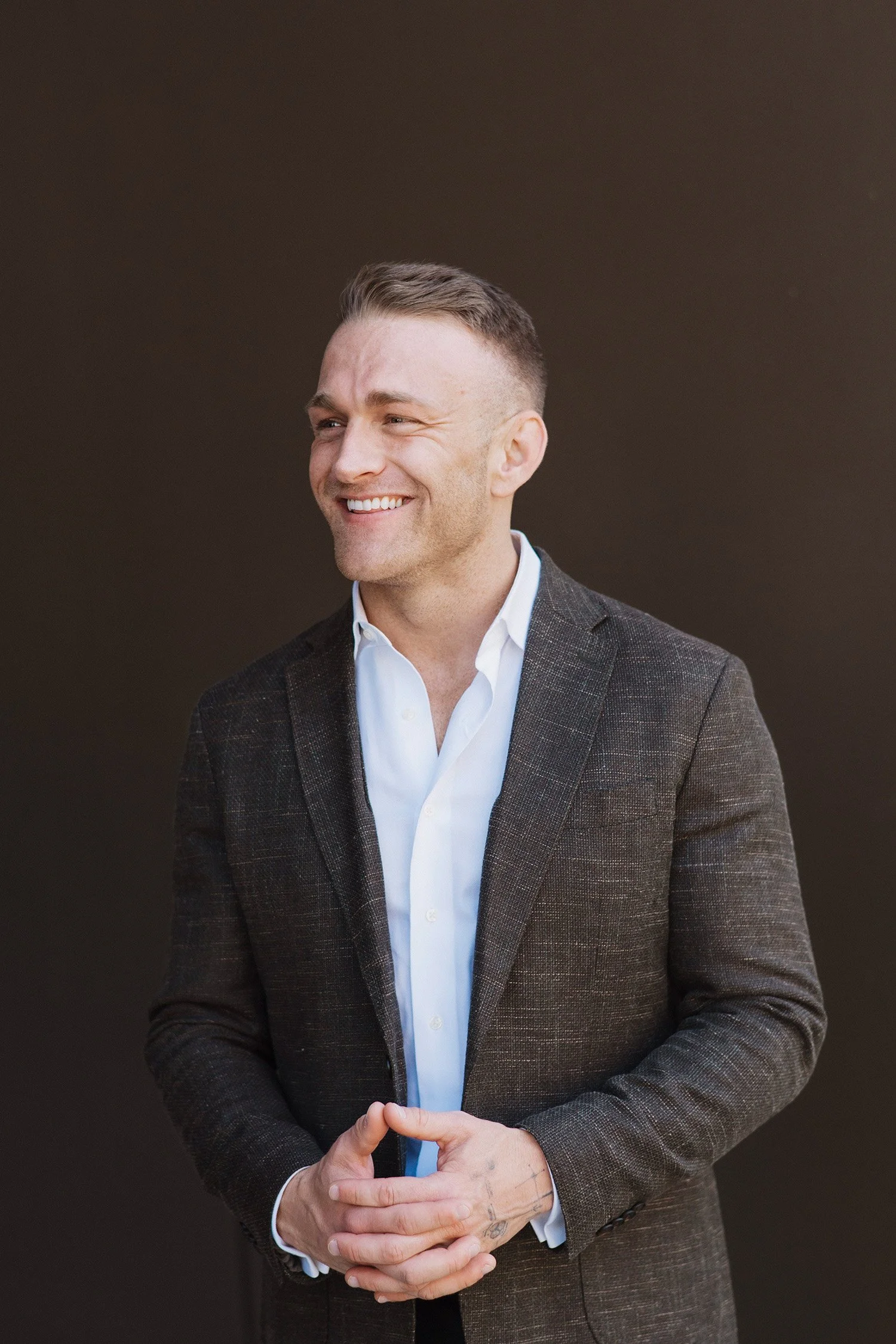 Highly recommended corporate photographer captures candid executive headshot with warm brown backdrop