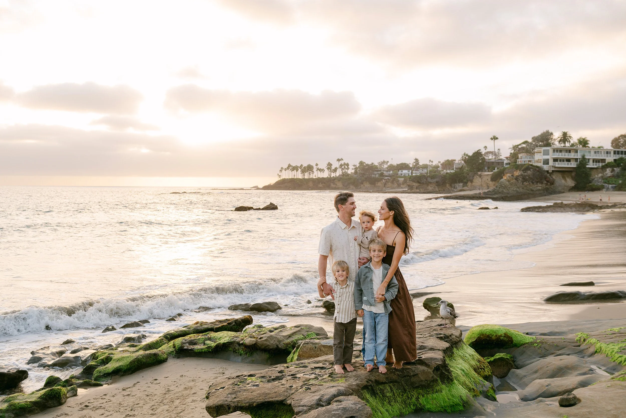 Award-winning family photographer in Orange County photographs family portrait on Laguna Beach coastline