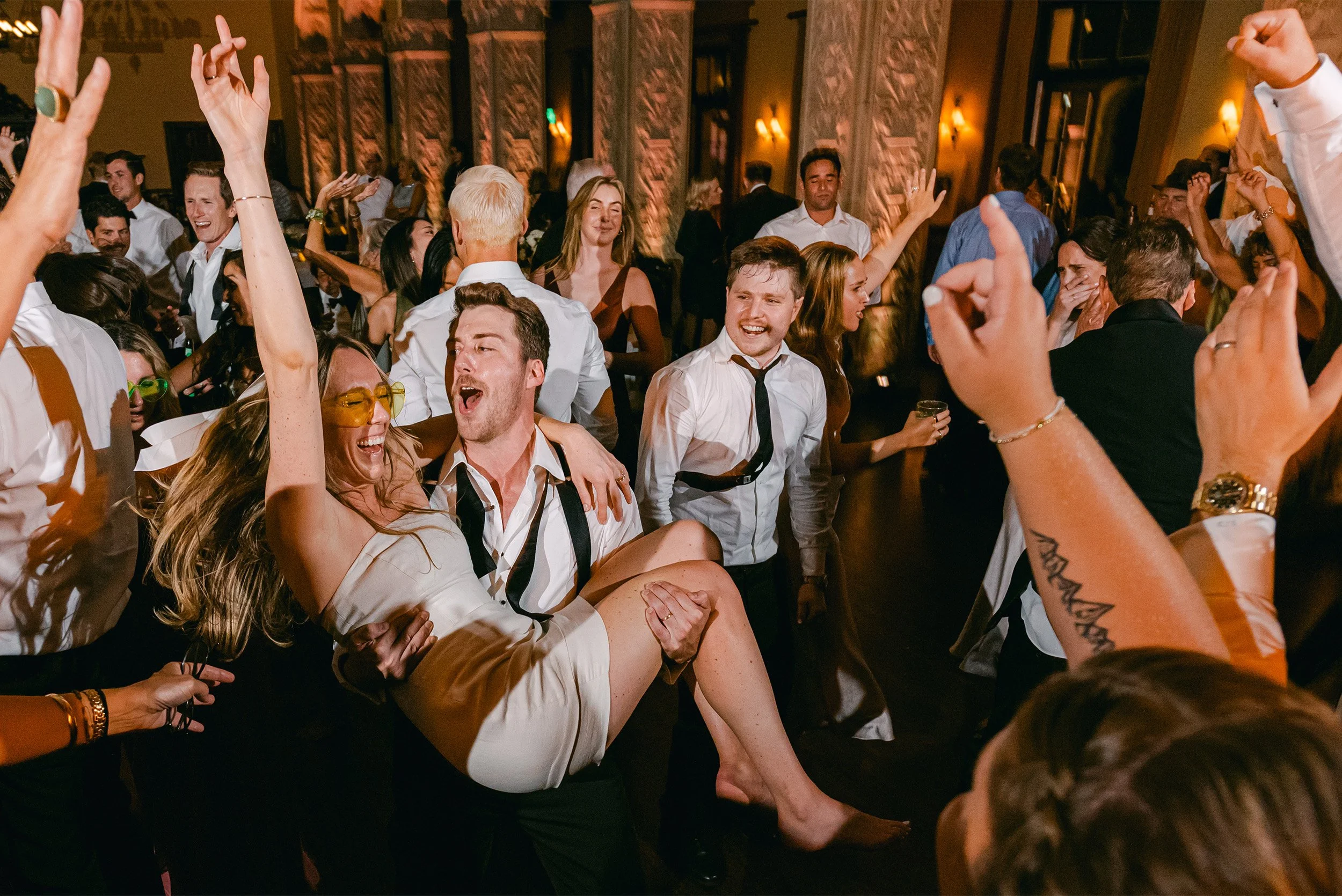 Orange County wedding photographer captures energetic reception dance floor moment with guests celebrating and laughing at The Ebell of Los Angeles