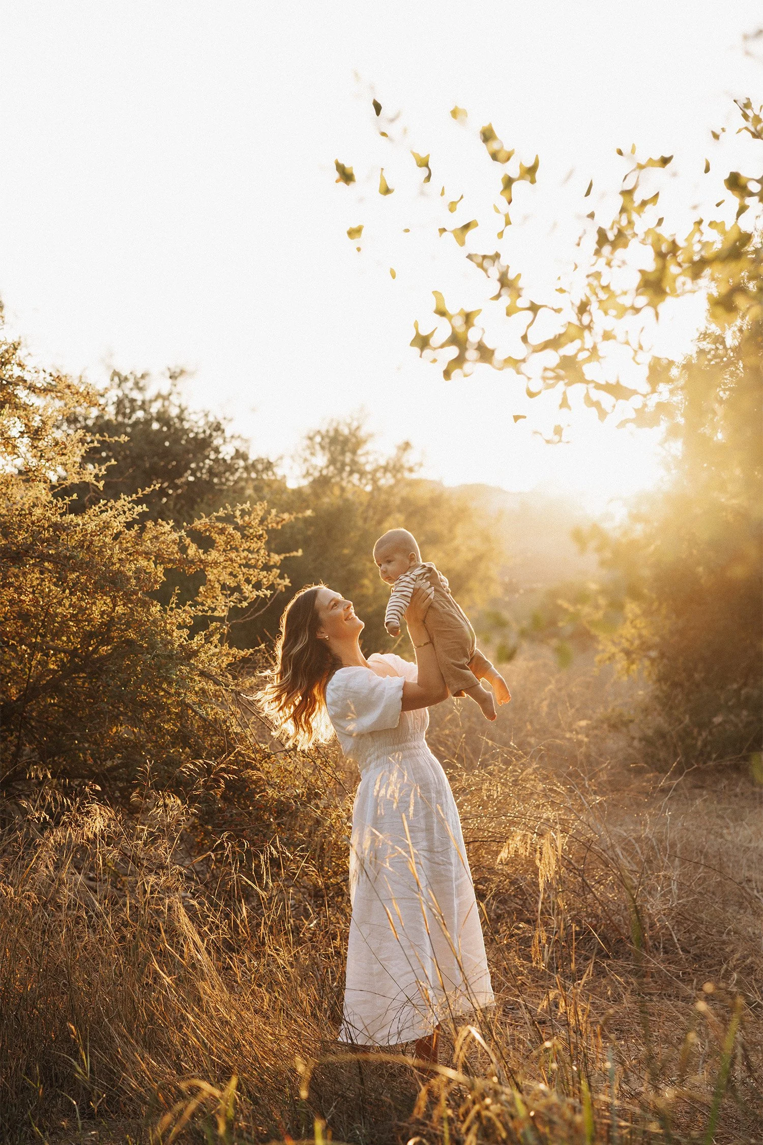 Mother lifting her baby joyfully in a sunset field in Orange County, Family photography locations