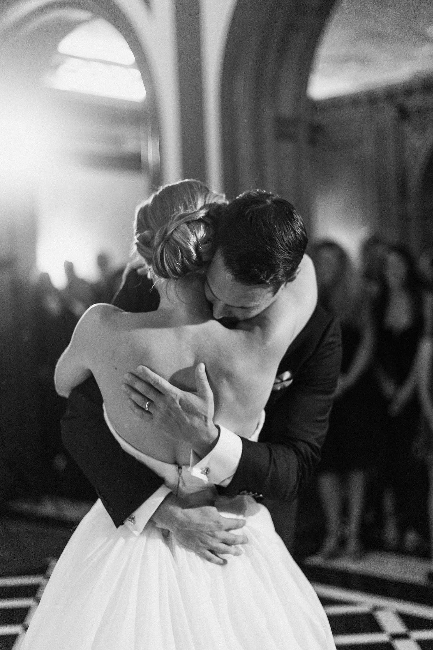 Bride and groom embracing during first dance at wedding reception, black and white candid photo at the Greystone Mansion & Gardens: The Doheny Estate in Beverly Hills