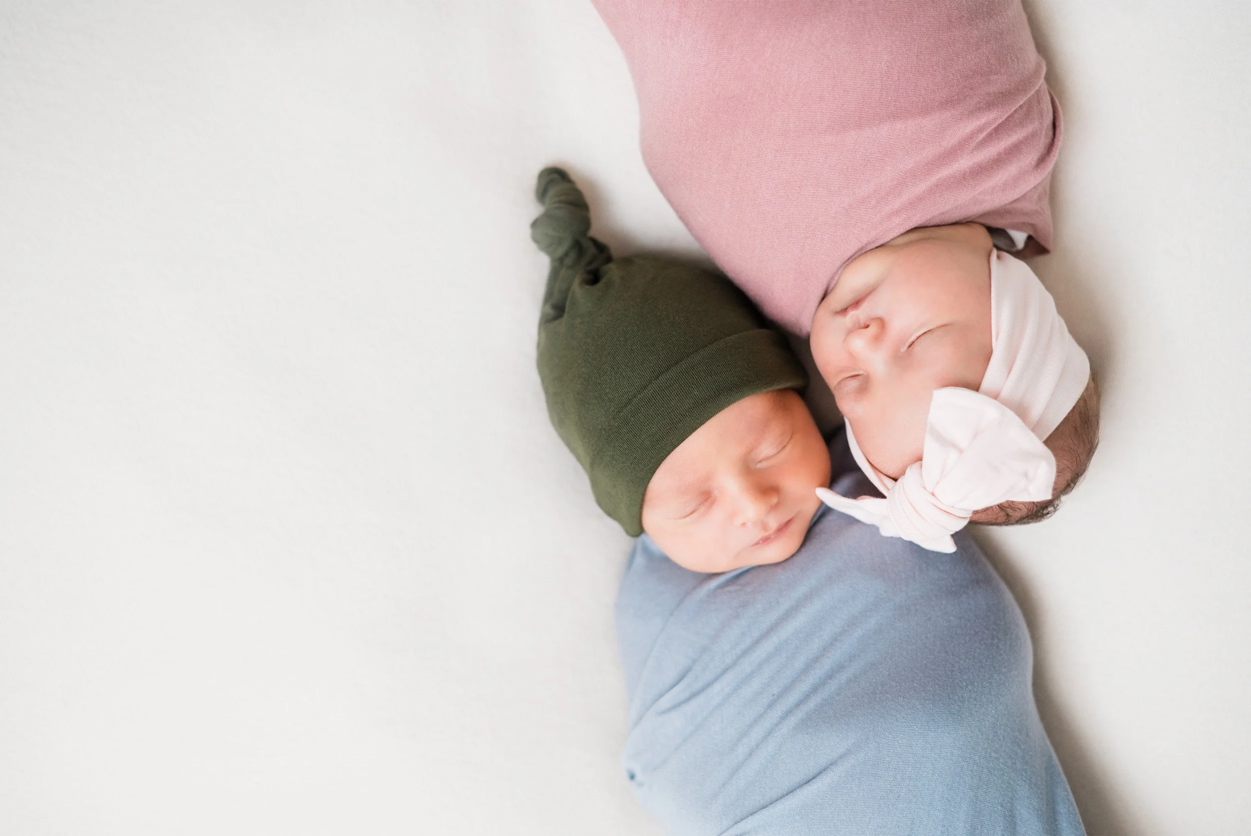 Orange County newborn photographer captures twin babies swaddled side by side in pink and blue