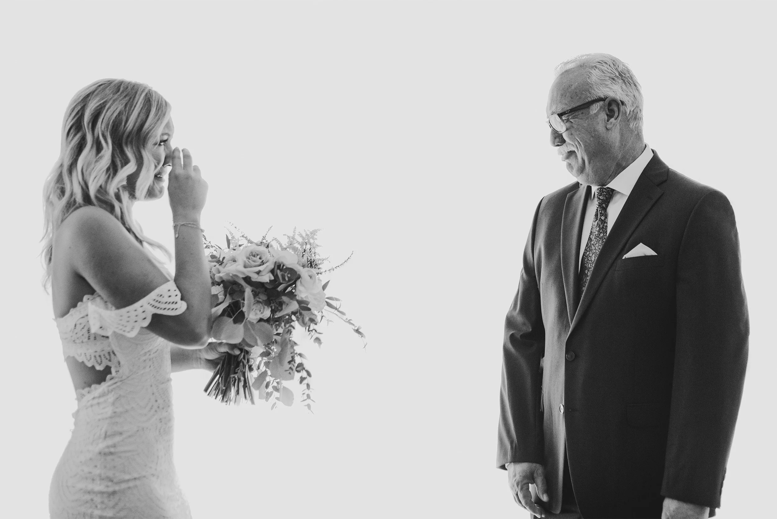 Bride wiping tears while looking at her father in black and white portrait, Orange County wedding photography