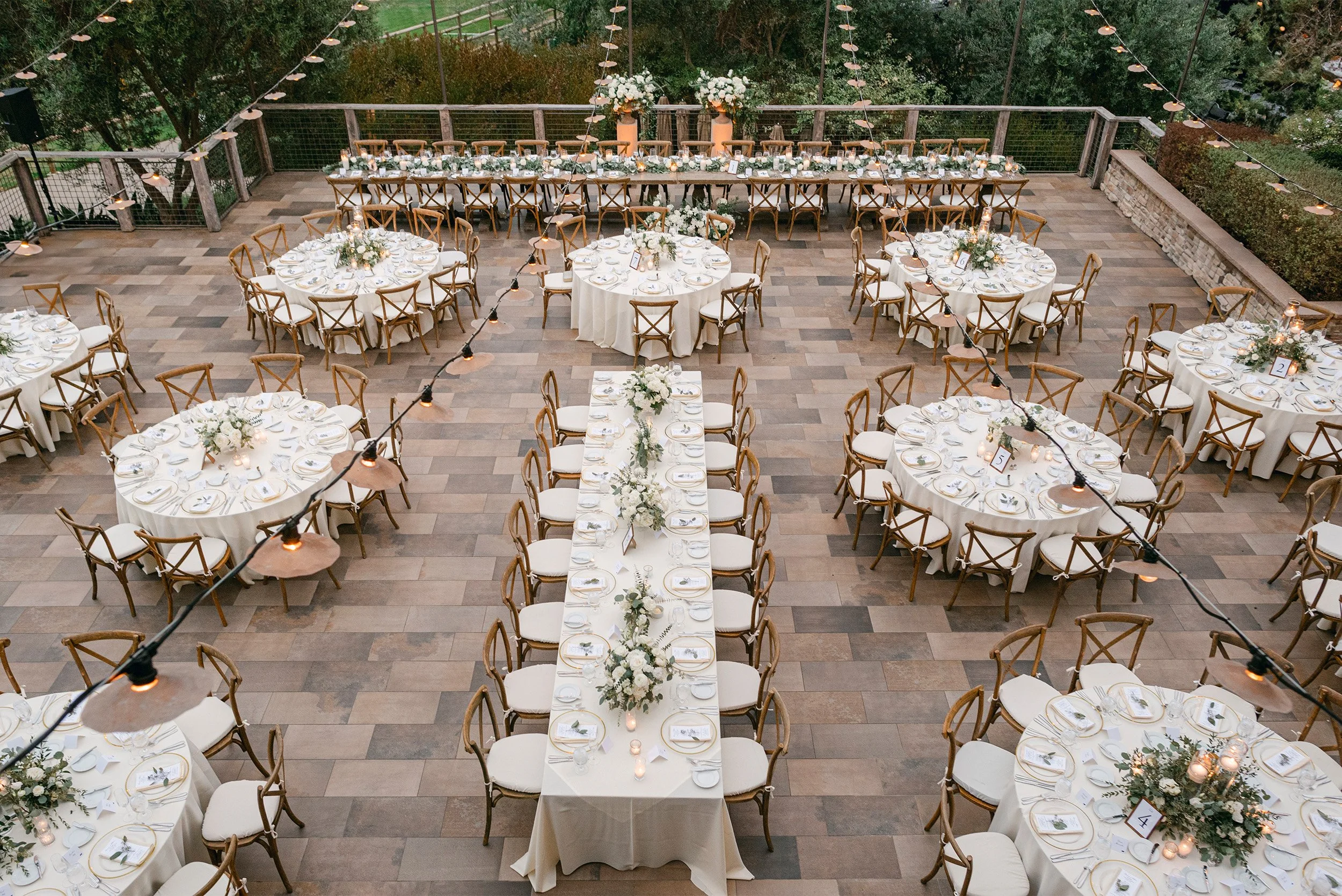 Orange County wedding photographer captures elegant outdoor reception tablescape with string lights and white floral centerpieces, aerial view of The Ranch at Laguna Beach