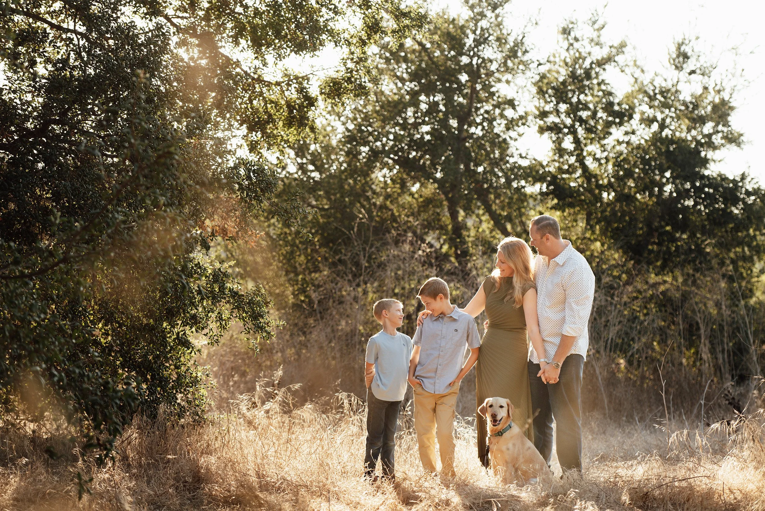 Pet-friendly award-winning family photographer in Orange County photographs family and dog under oak tree