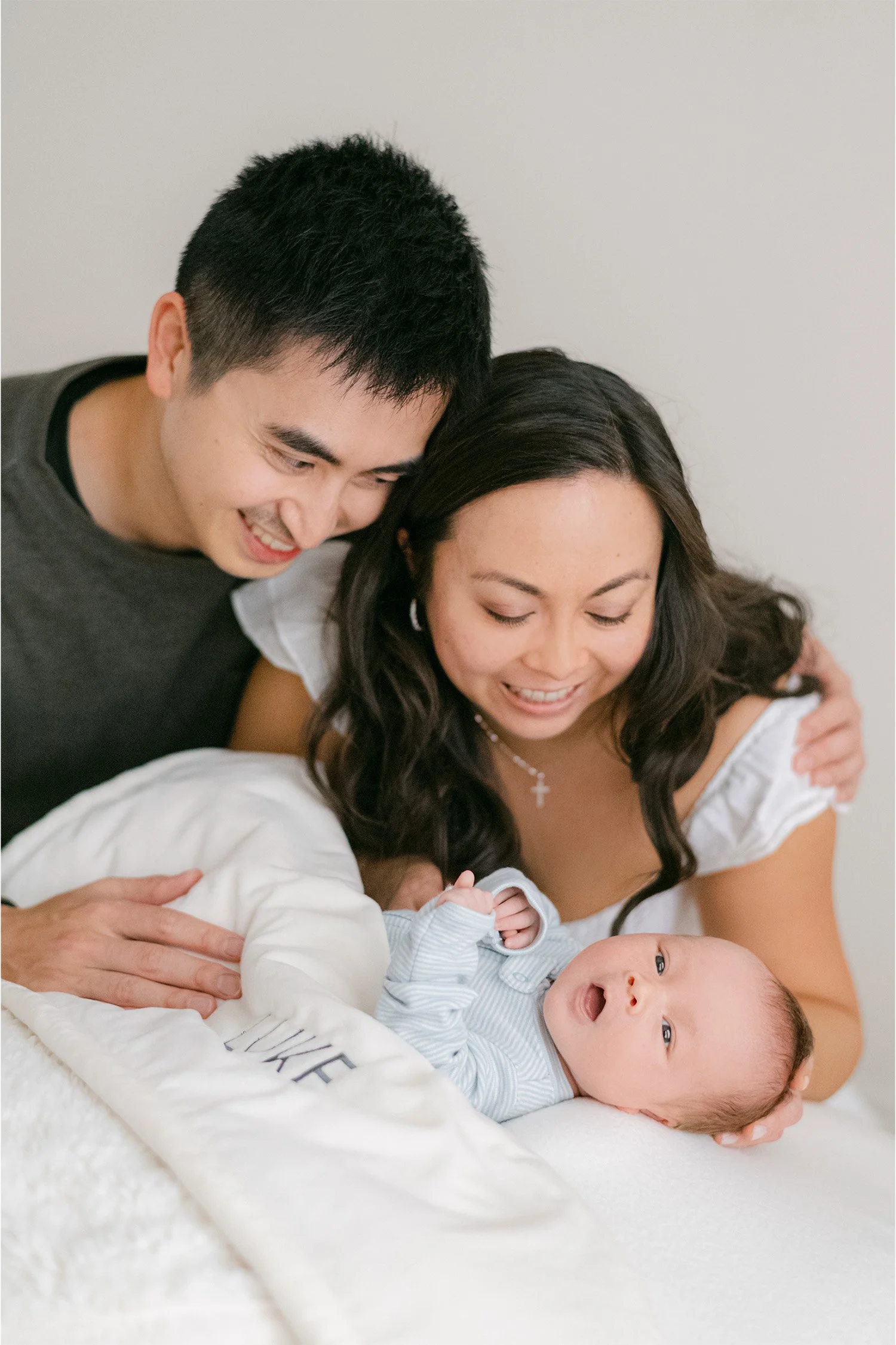 Parents smiling at newborn on personalized blanket, Orange County baby photographer