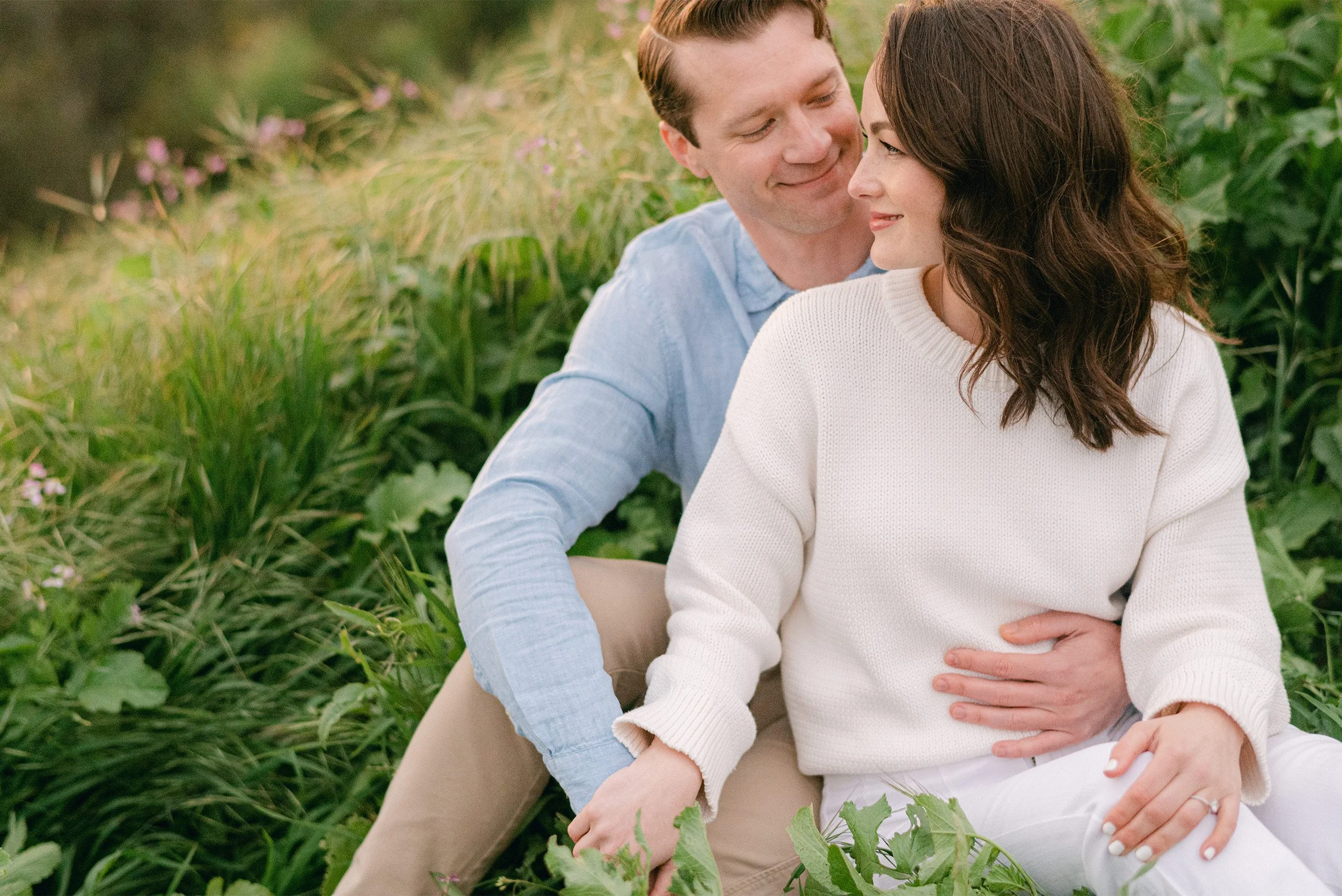 Santa Barbara engagement photographer captures couple smiling closely together in a field of tall grass
