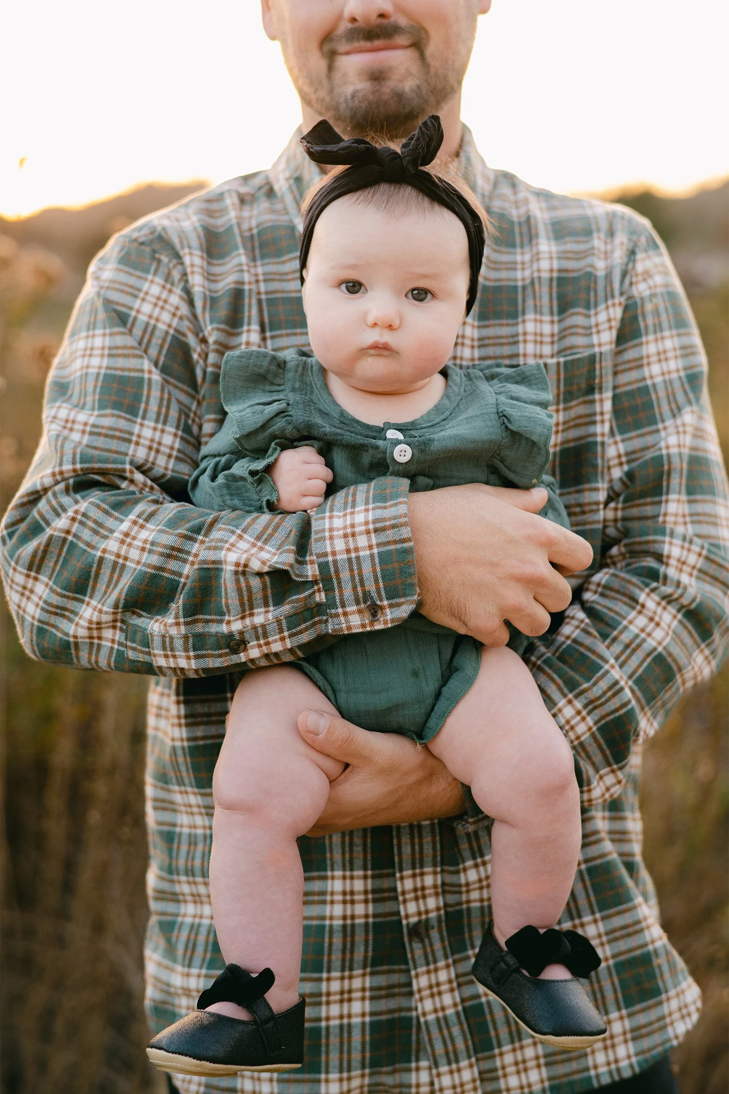 Father holding baby girl in a plaid shirt at golden hour, Highly recommended family photographer in Orange County