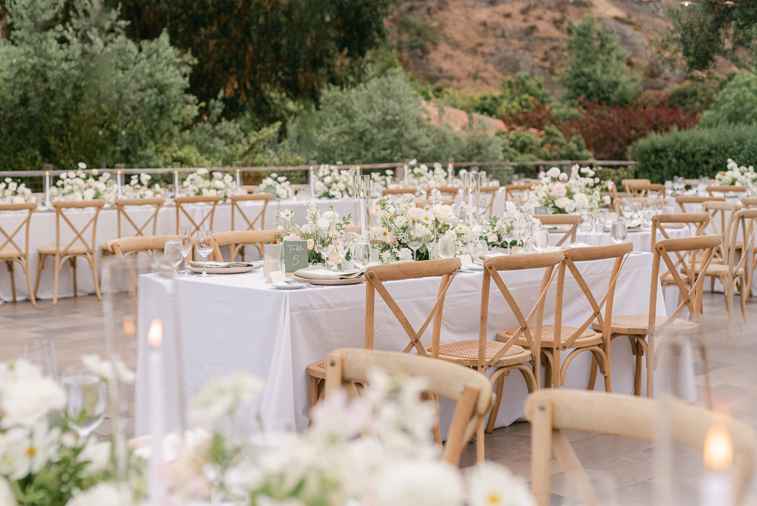Orange County wedding photographer captures elegant outdoor wedding reception tablescape with white florals and hill backdrop at The Ranch at Laguna Beach