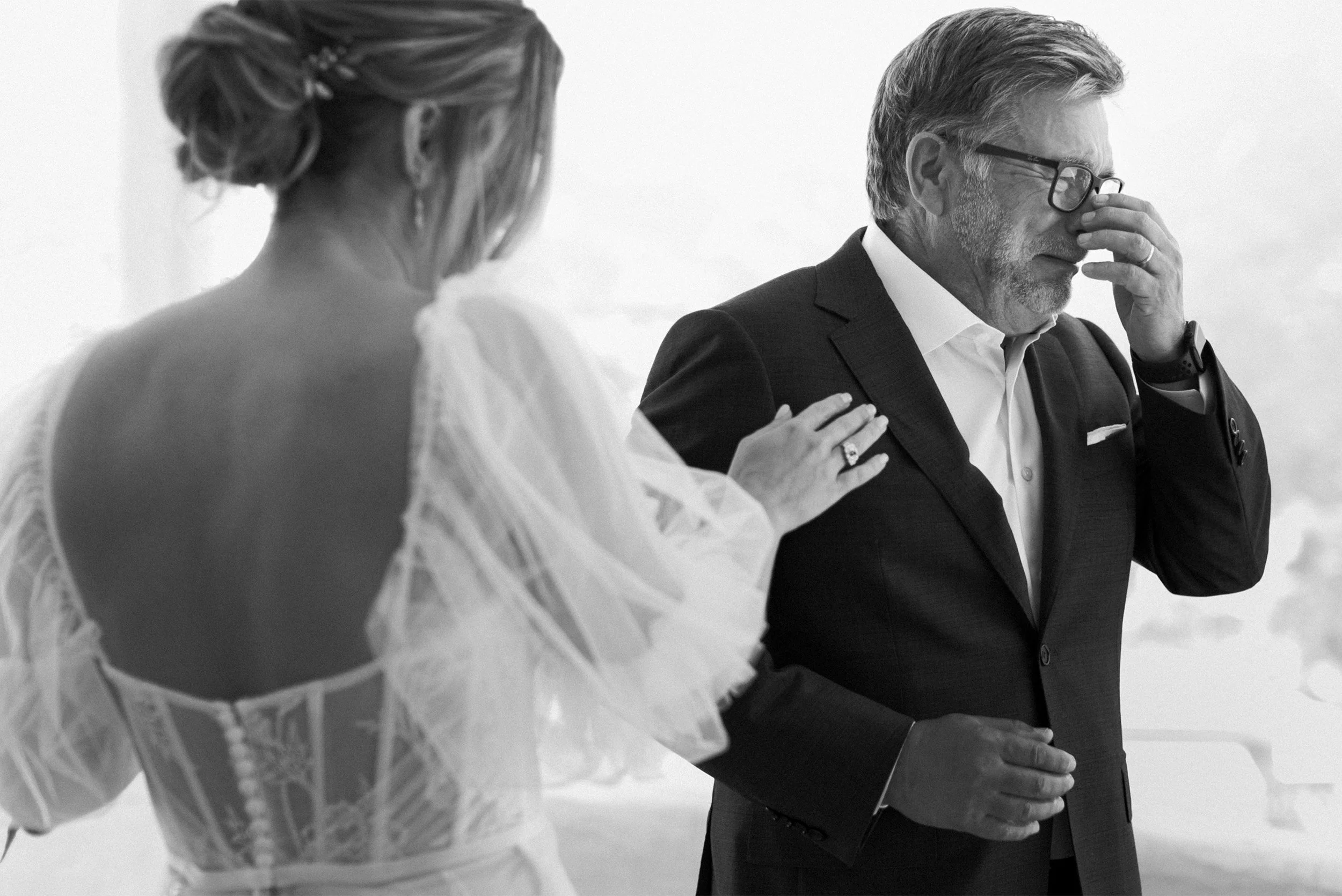 Orange County wedding photographer captures emotional father of the bride wiping tears as daughter comforts him, black and white, Catalina Island Wedding