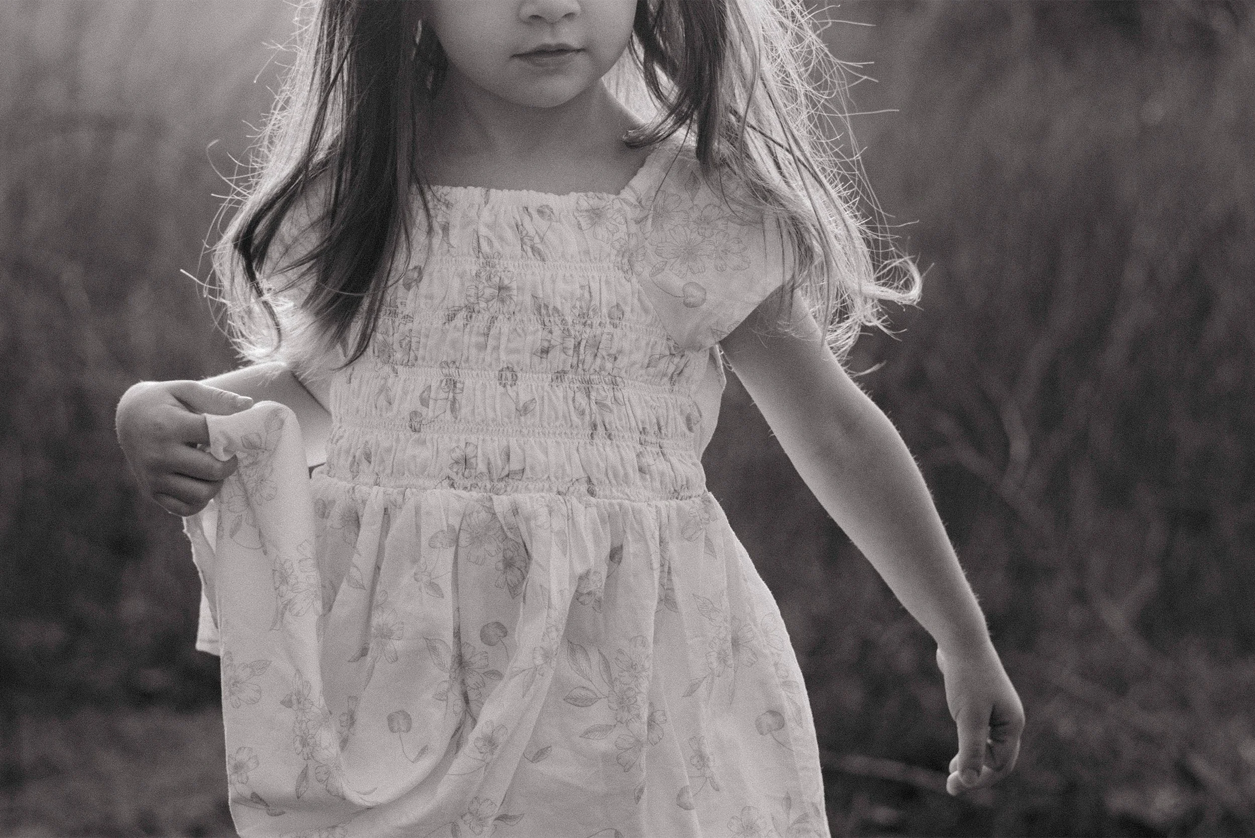 Black and white detail portrait of girl in floral dress outdoors, Orange County family photographer