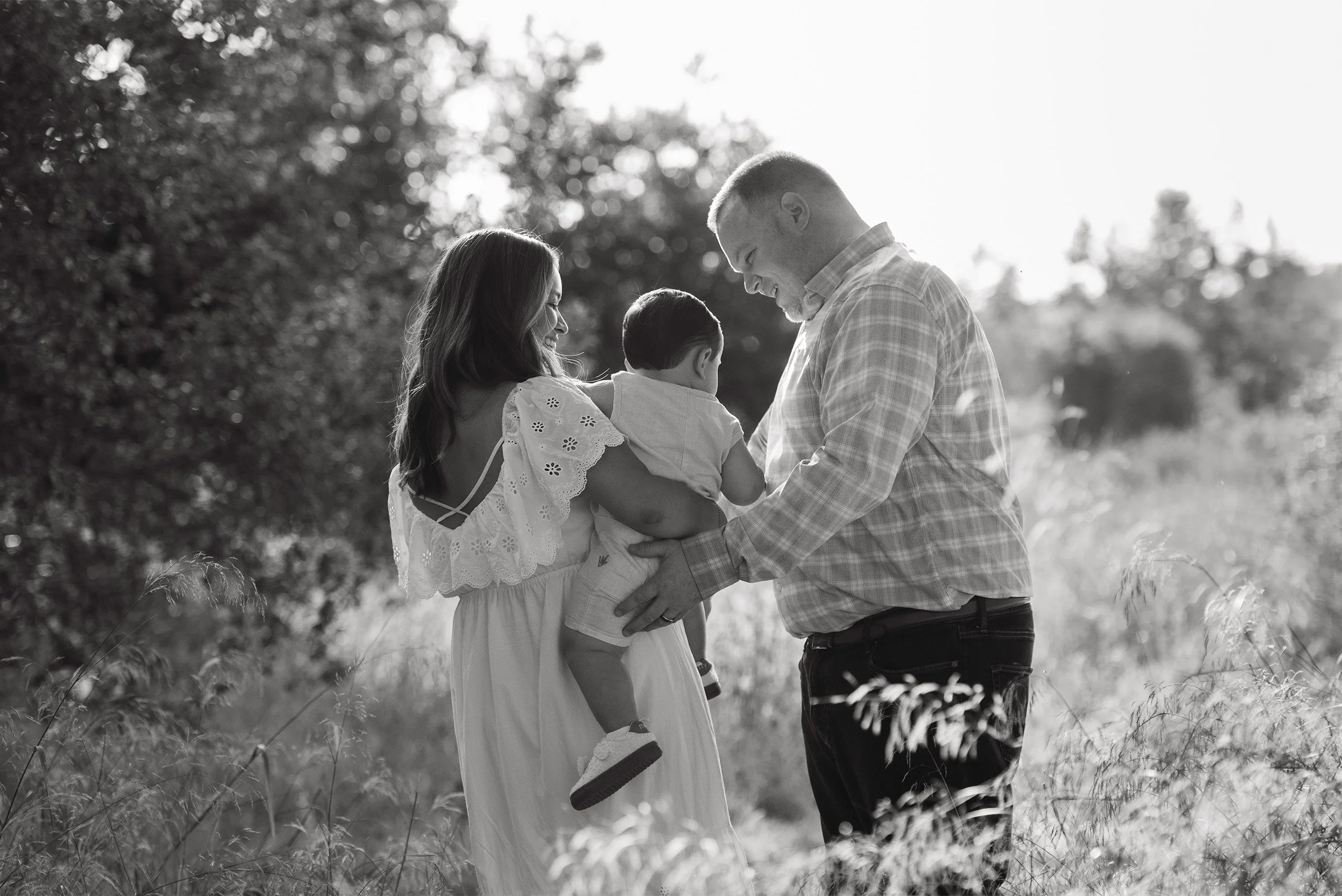 Orange County family photographer captures black-and-white family moment in grassy field