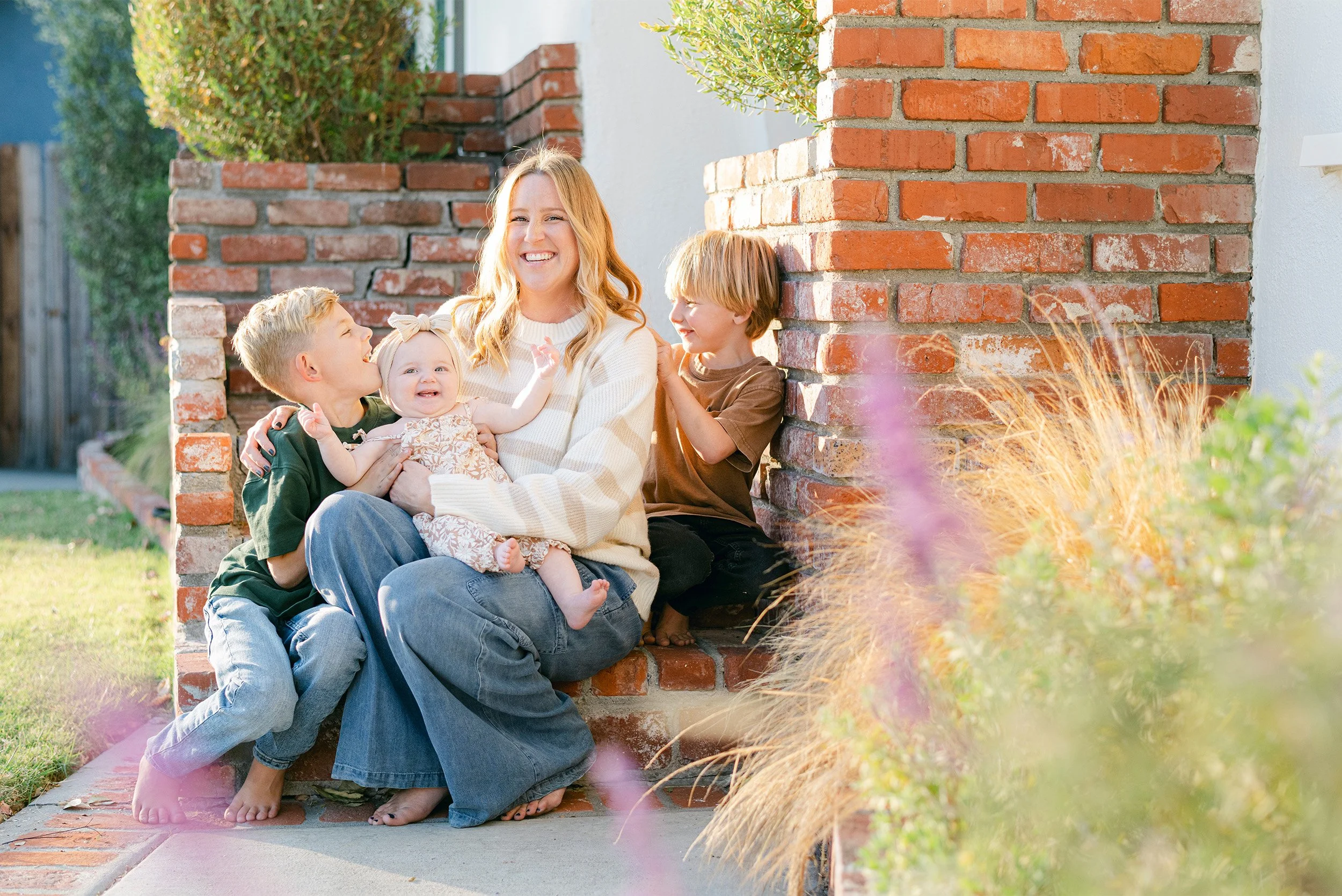 Mother laughing with three children on brick steps, Highly recommended family photographer in Orange County