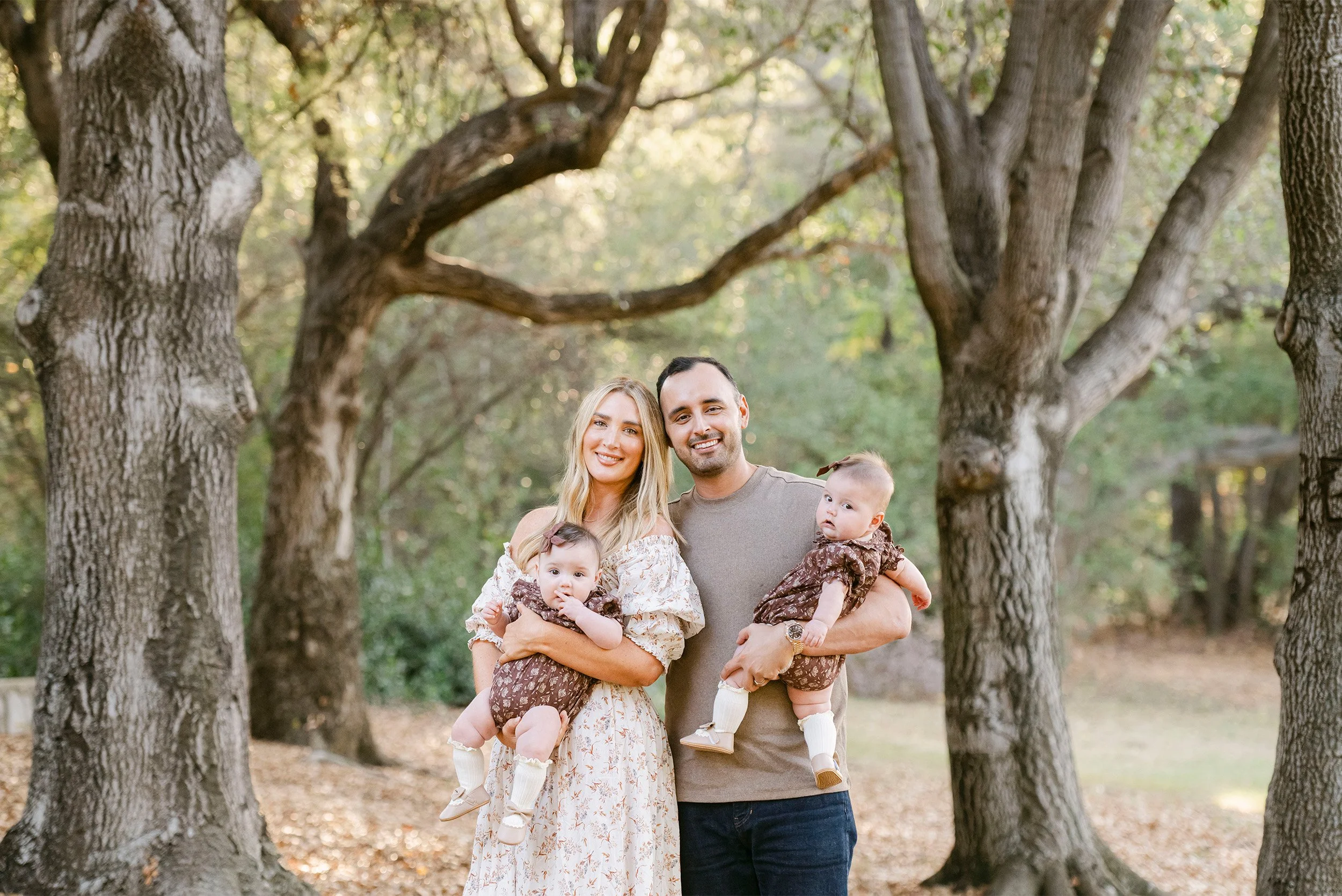 Award-winning family photographer in Orange County photographs parents with twin baby girls at Irvine Park