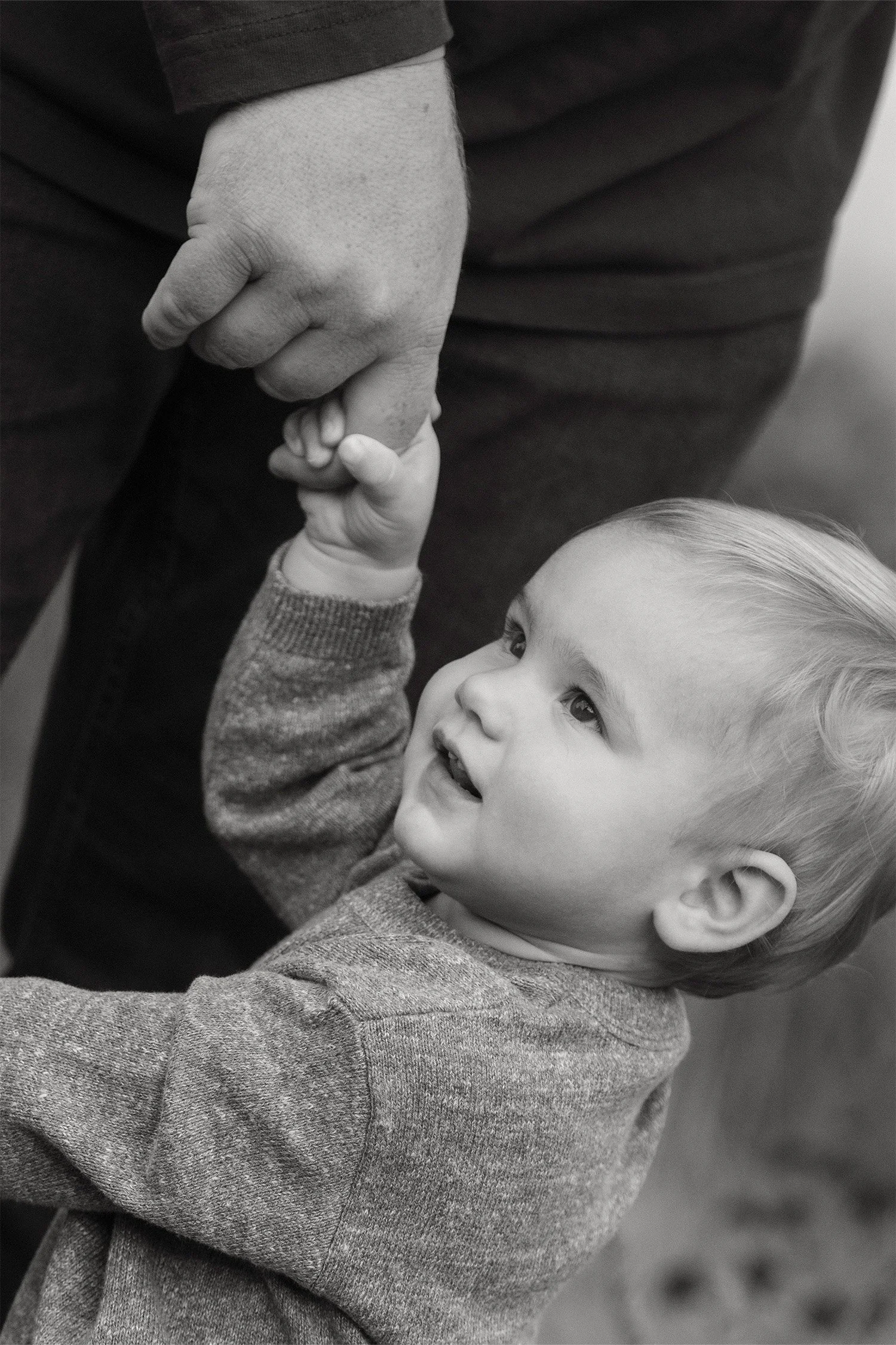 Black and white close-up of baby holding father's hand, Family photography in Orange County
