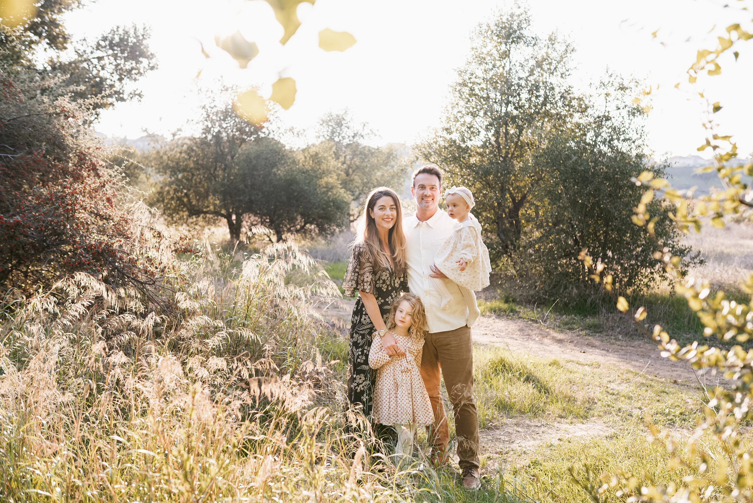 Orange County family photographer captures family portrait in golden autumn field at sunset
