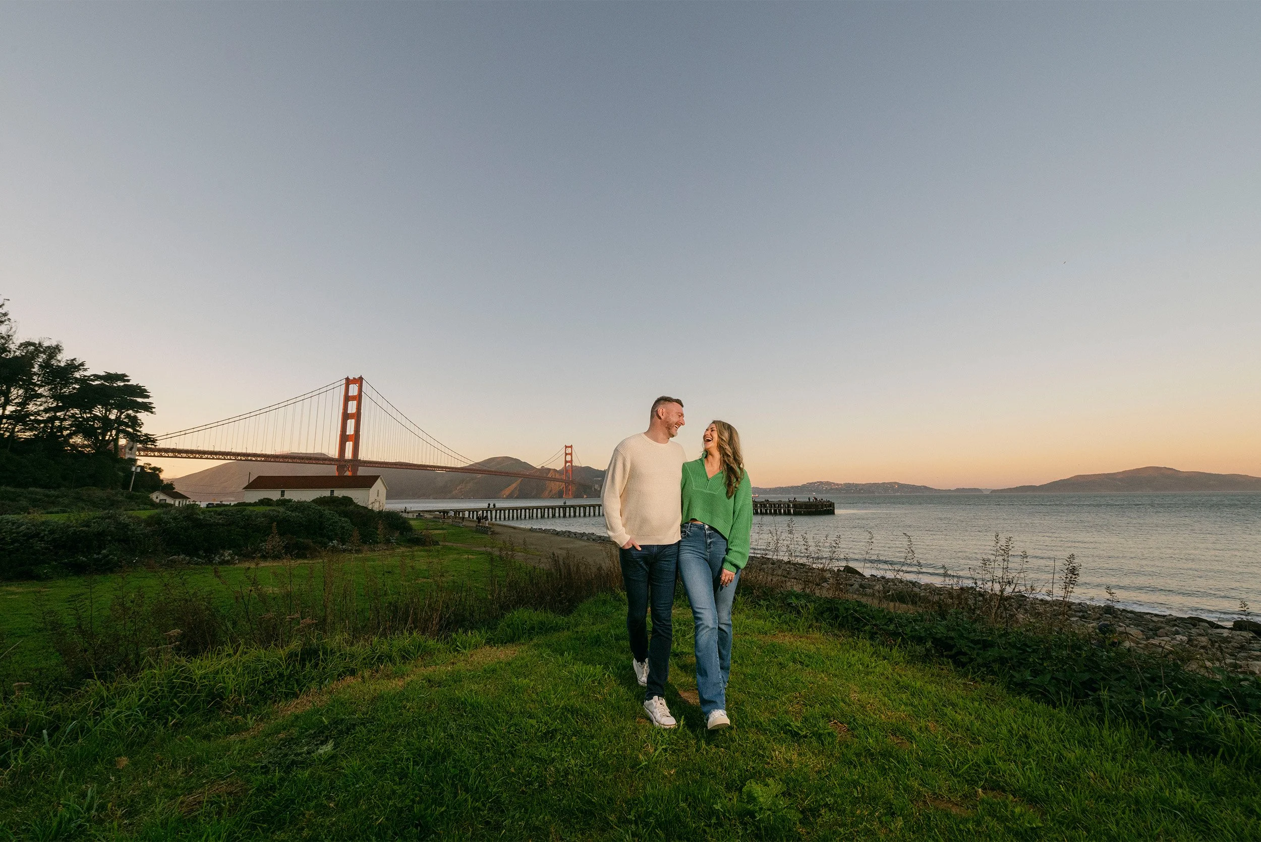 Orange County engagement photographer captures couple walking together at sunset near the Golden Gate Bridge in San Francisco