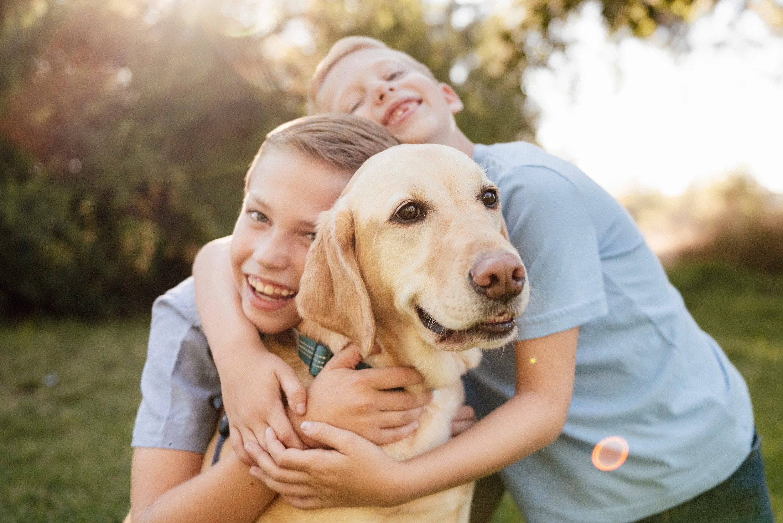Pet-friendly Orange County family photographer captures siblings hugging their golden Labrador
