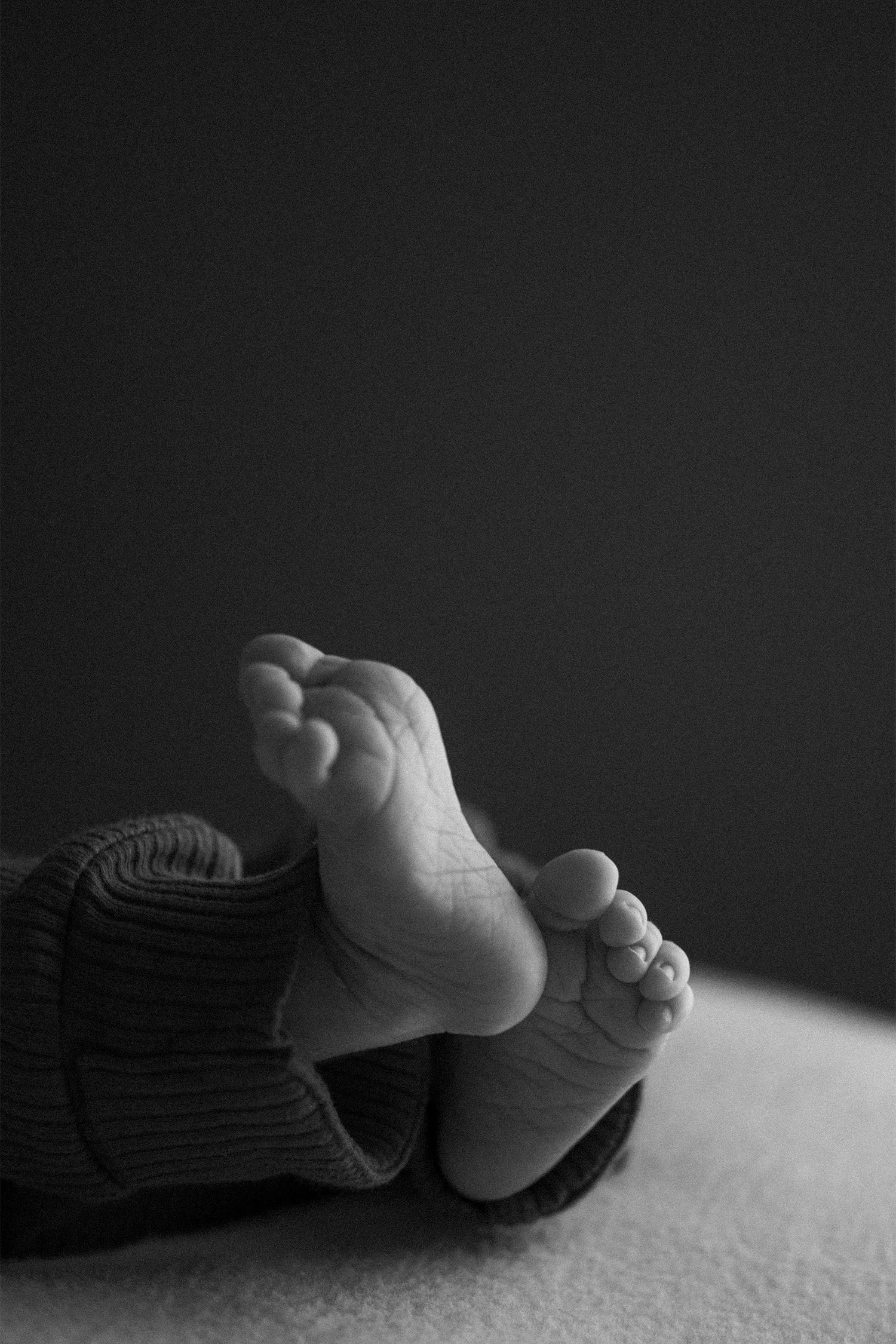 Black and white close-up of newborn's bare feet, award-winning baby photographer in Orange County