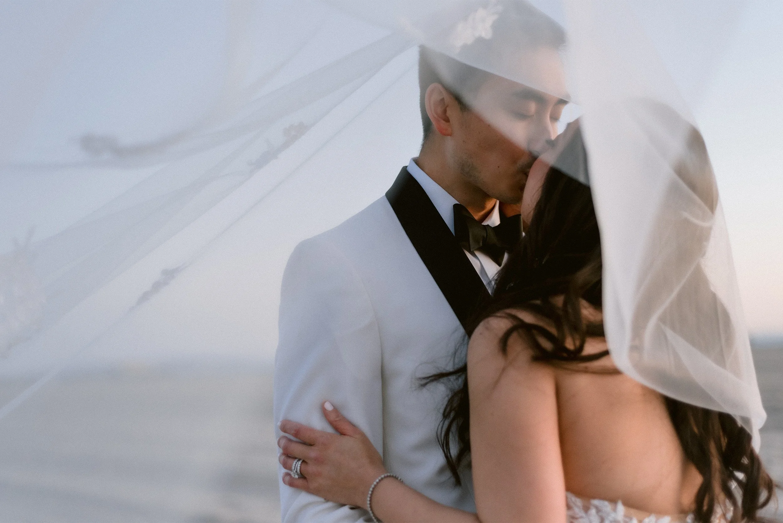 Highly recommended wedding photographer in Santa Monica captures romantic kiss as veil wraps around embracing couple at the Proper Hotel