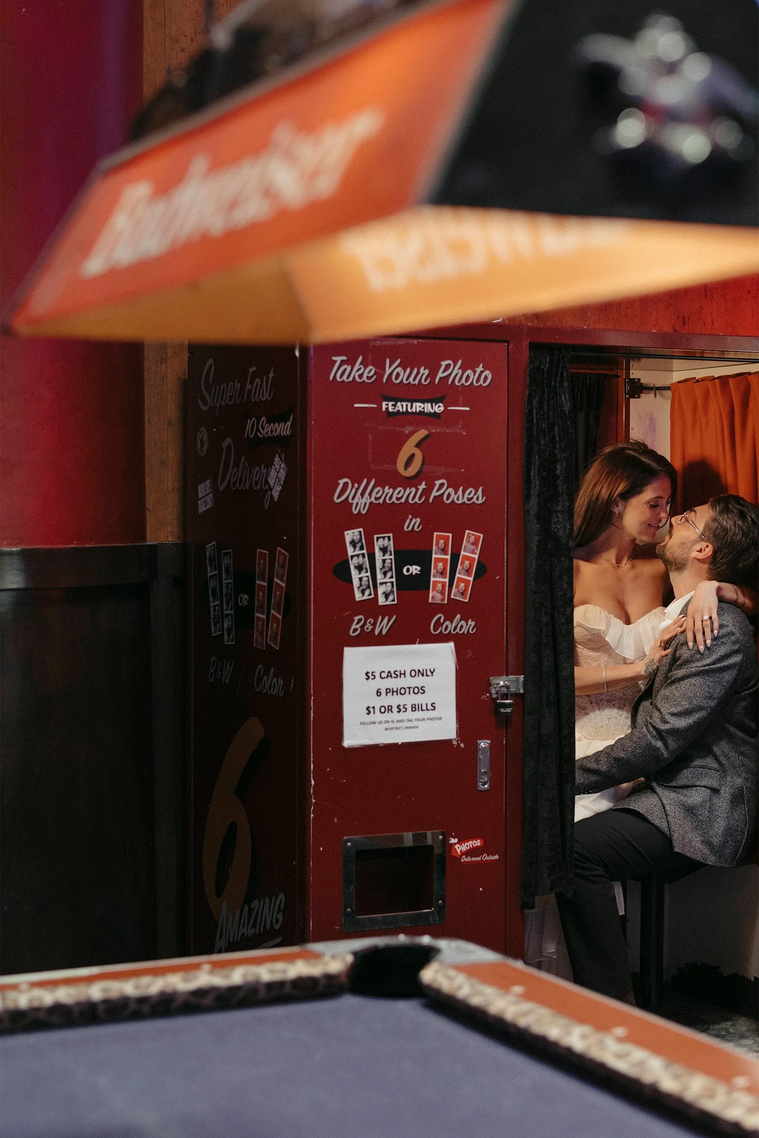 Award-winning engagement photographer in Orange County captures couple snuggled in vintage photo booth