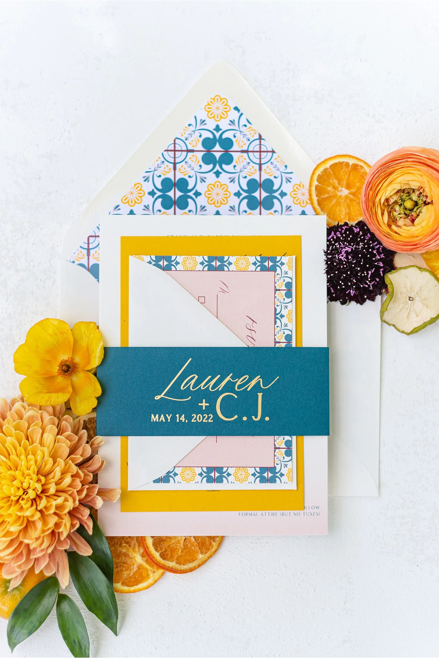 Colorful wedding invitation suite with floral tile pattern and orange dried citrus, stationery flat lay