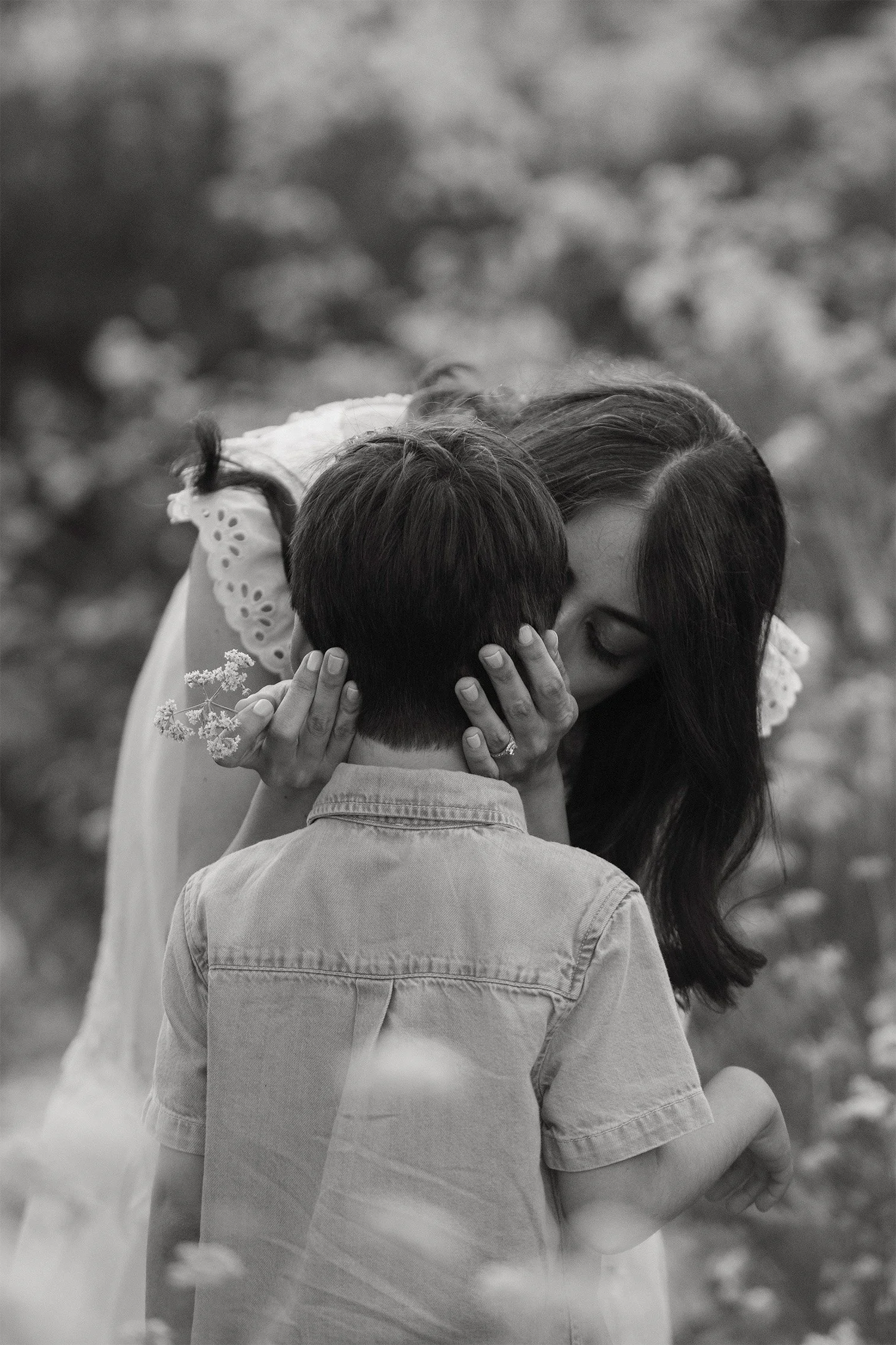 Highly recommended family photographer captures intimate moment of mother embracing son in a wildflower field in Orange County