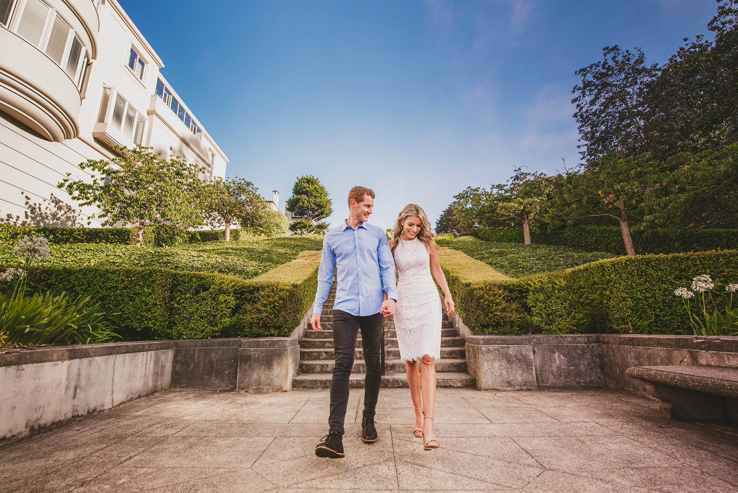 Couple walking hand in hand down garden steps in front of an elegant estate, Pacific Heights San Francisco engagement photos