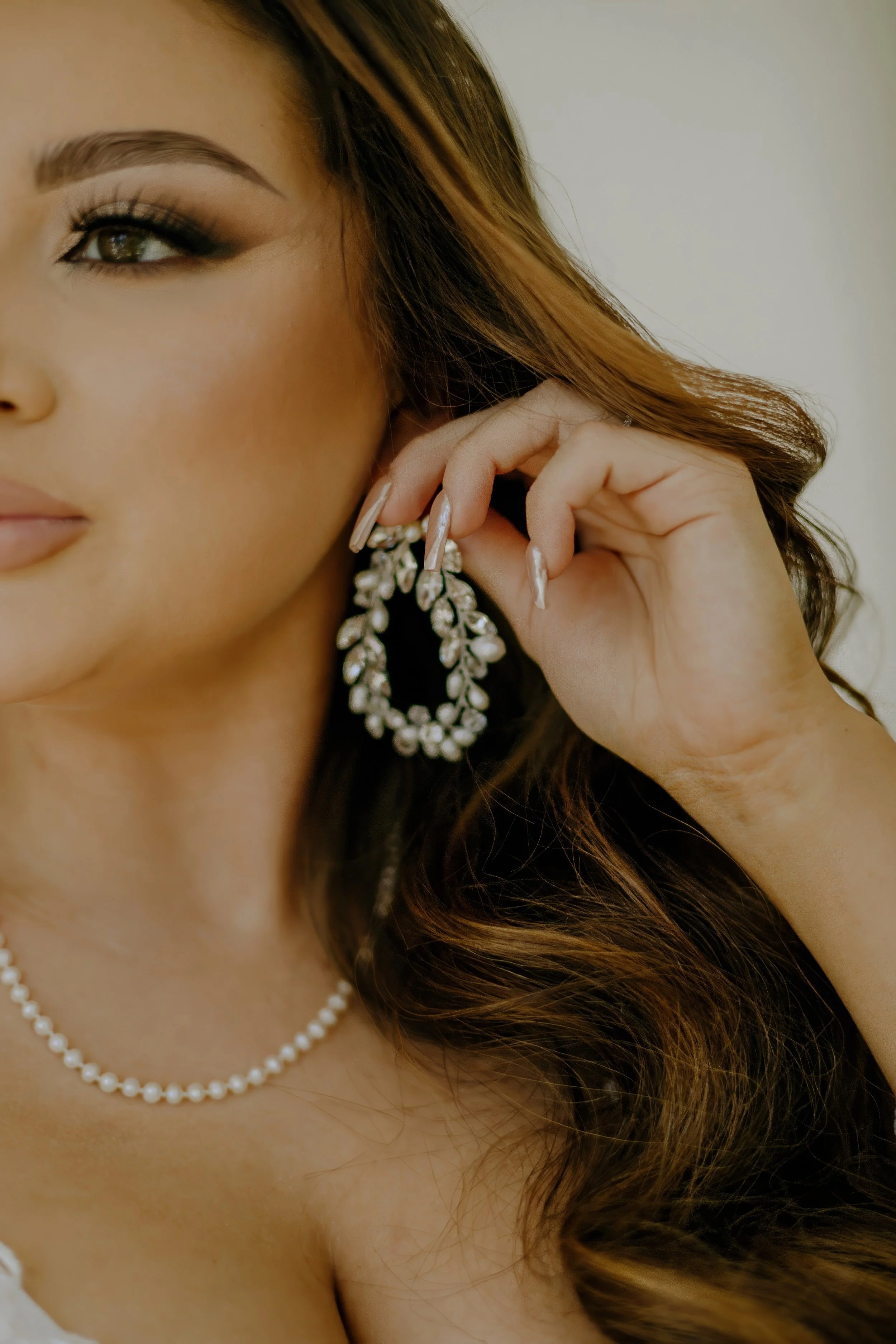 Houston & Texas Family, Couples, Newborn, Maternity, Bridal Photography – Bride adjusting pearl earrings, close-up elegance, Houston studio.