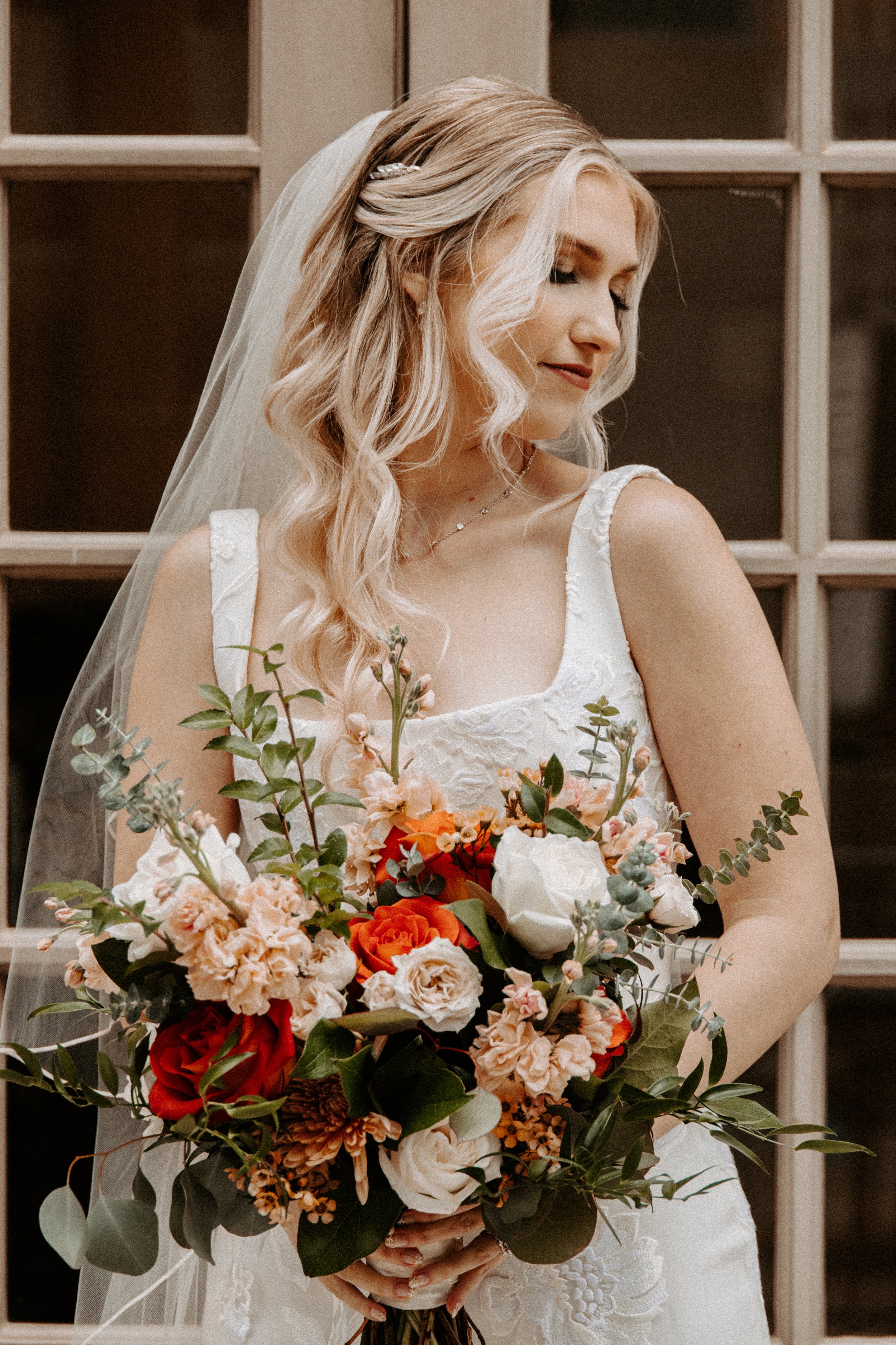 Wedding & Elopement Photography, Bride holding floral bouquet in front of vintage French doors.