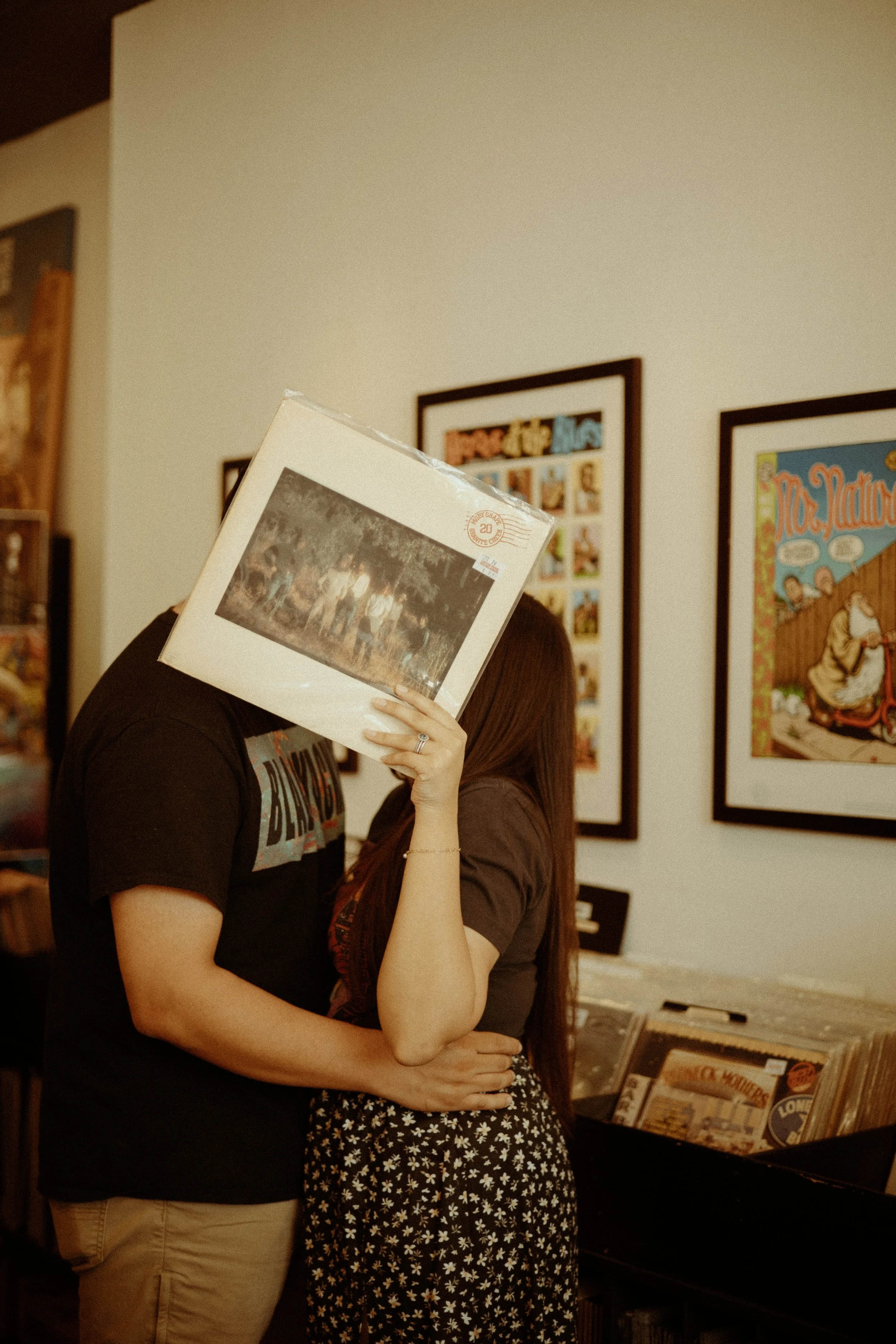Couples Portrait Photography, Houston TX – romantic moment hiding behind album sleeve while sharing a kiss