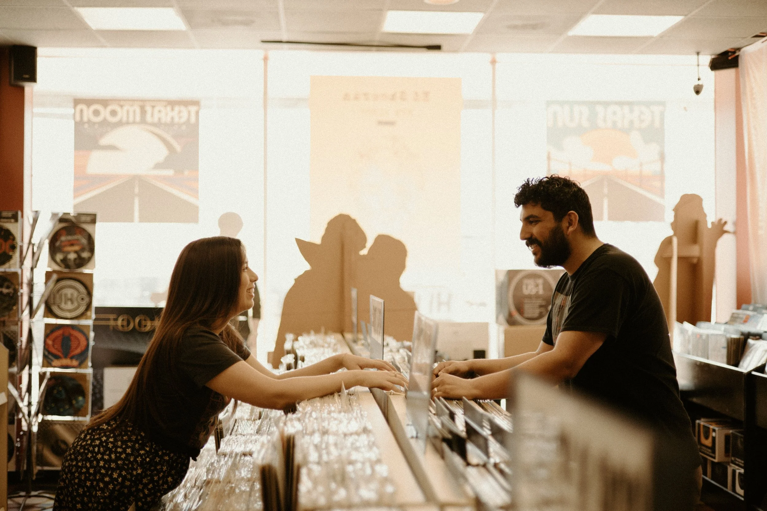 Couples Portrait Photography, Houston TX – warm-toned indoor scene of couple smiling across record display