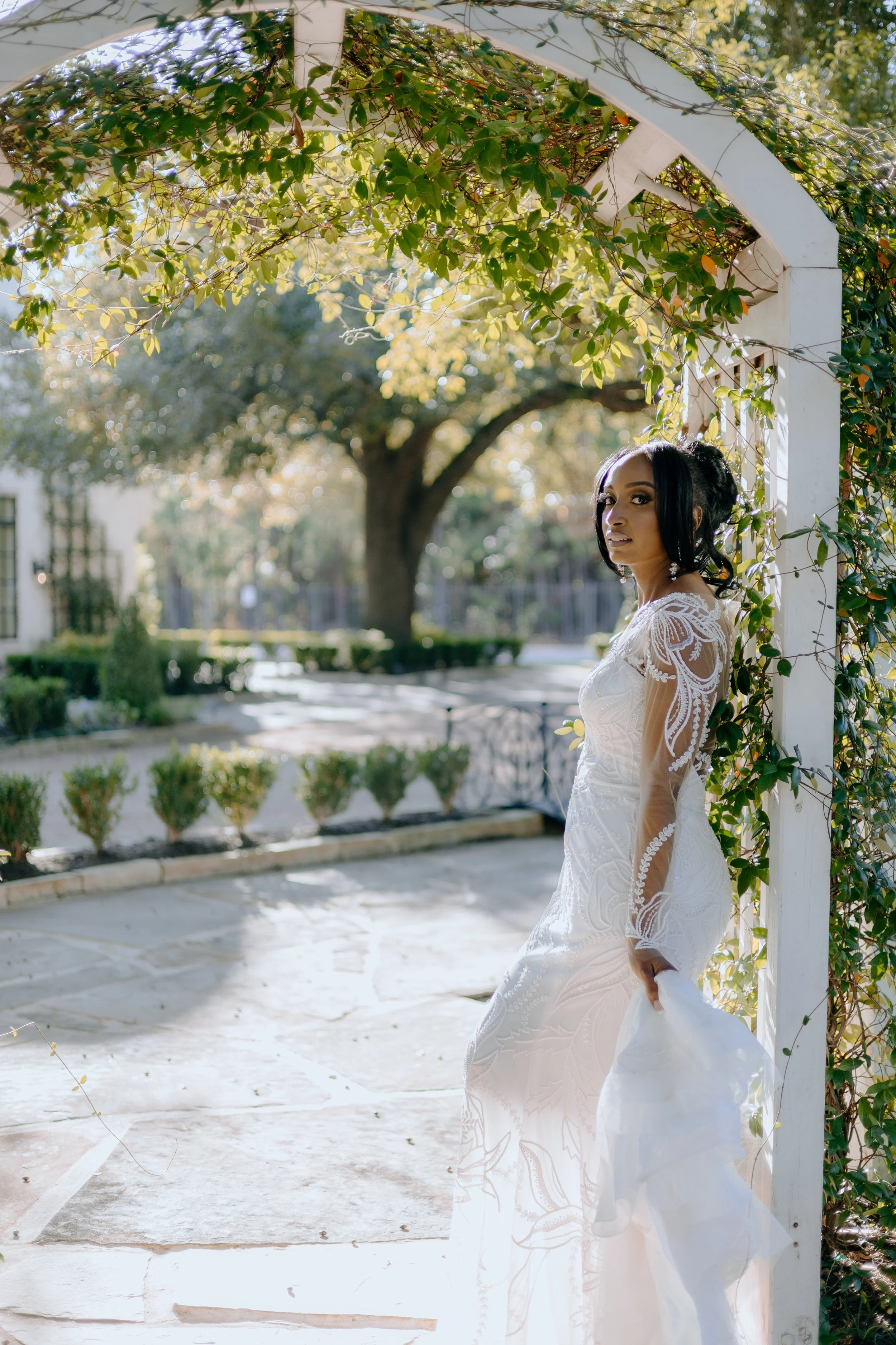 Houston & Texas Family, Couples, Newborn, Maternity, Bridal Photography – Bride walking under floral arch in The Woodlands TX.