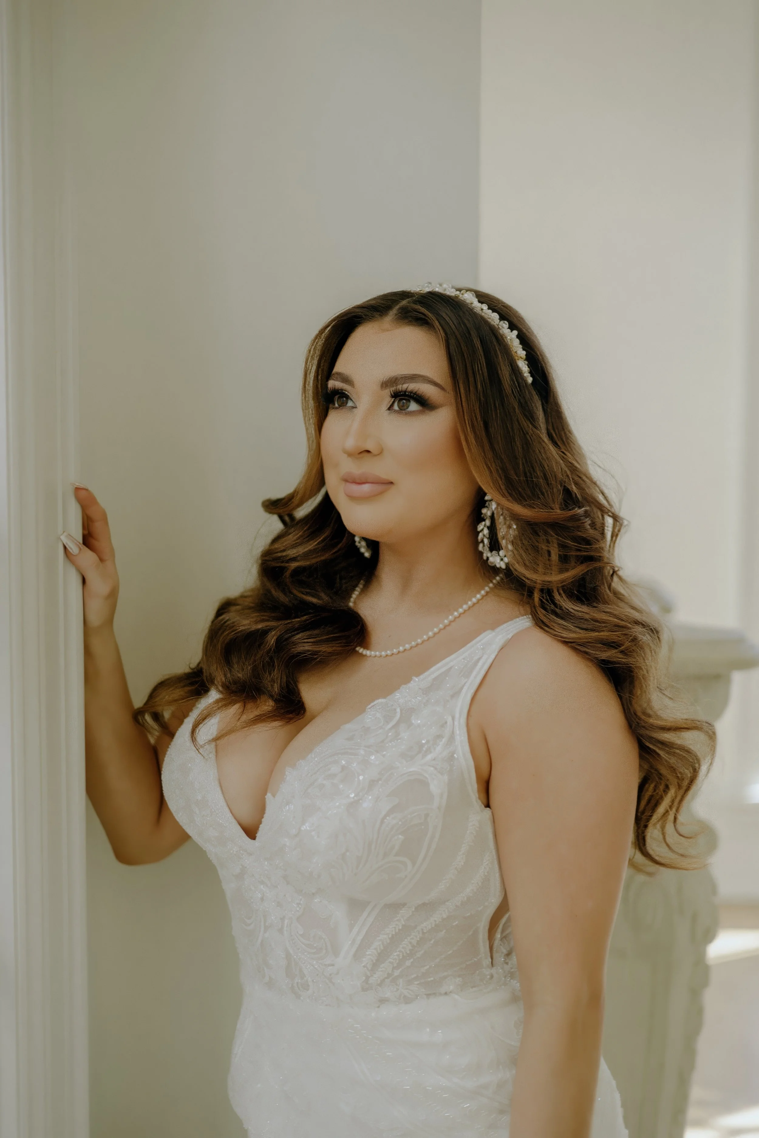 Houston & Texas Family, Couples, Newborn, Maternity, Bridal Photography – Bride resting hand on wall, highlighting gown details in Houston studio.