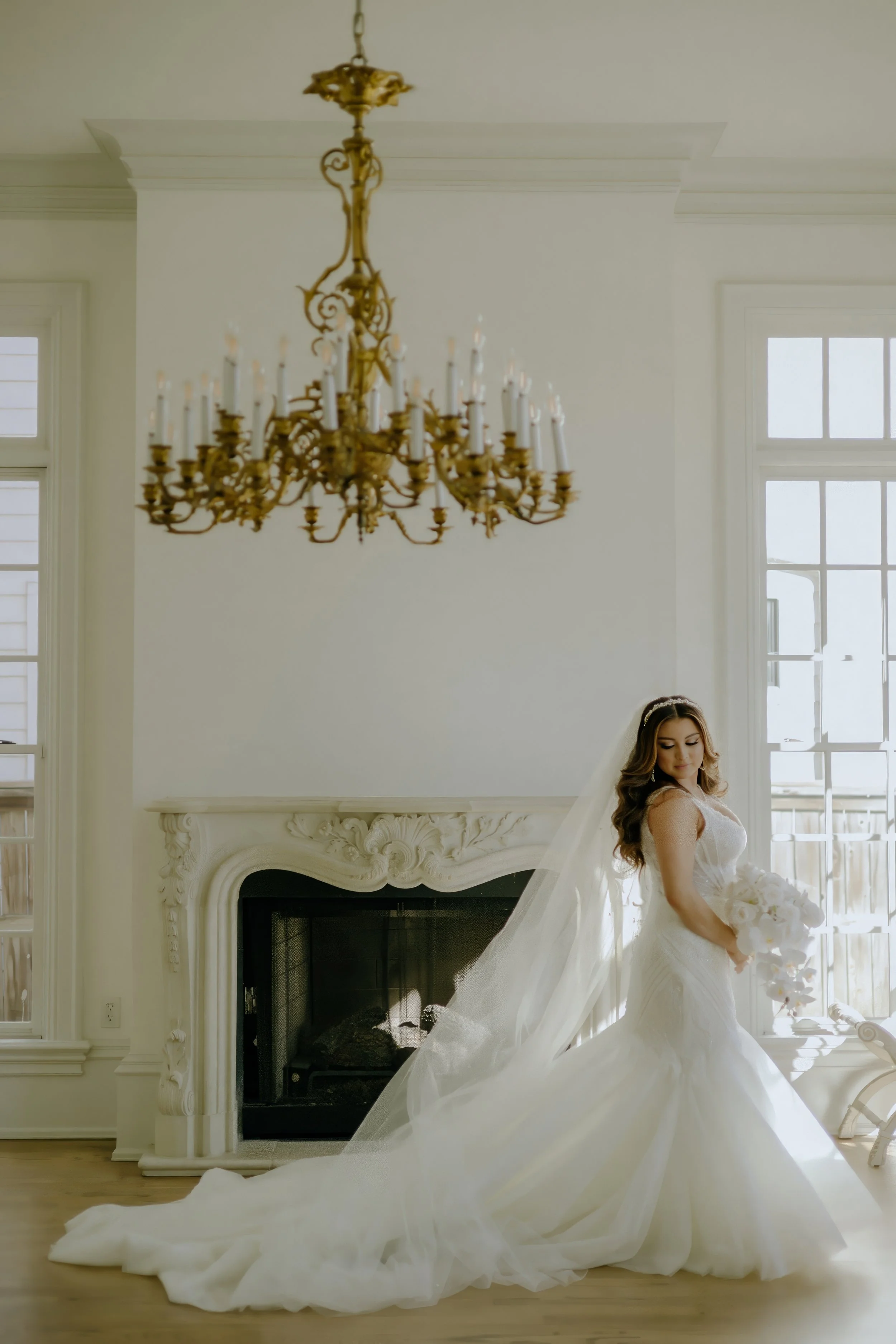 Houston & Texas Family, Couples, Newborn, Maternity, Bridal Photography – Bride framed in golden light beneath chandelier, Houston venue.