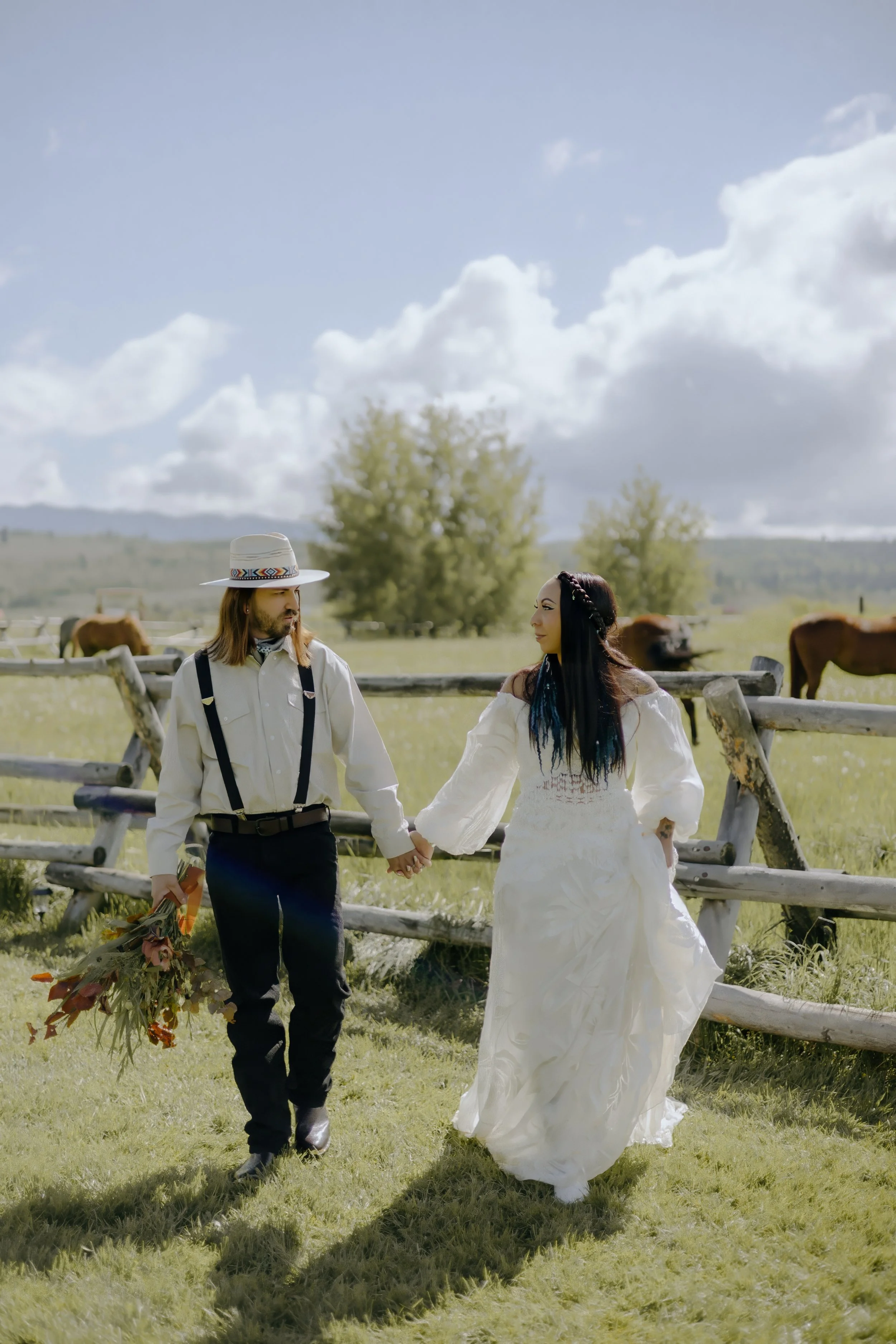 Houston & Texas Wedding & Elopement Photography – Couple laughing together in field with distant horses at Diamond Cross Ranch.