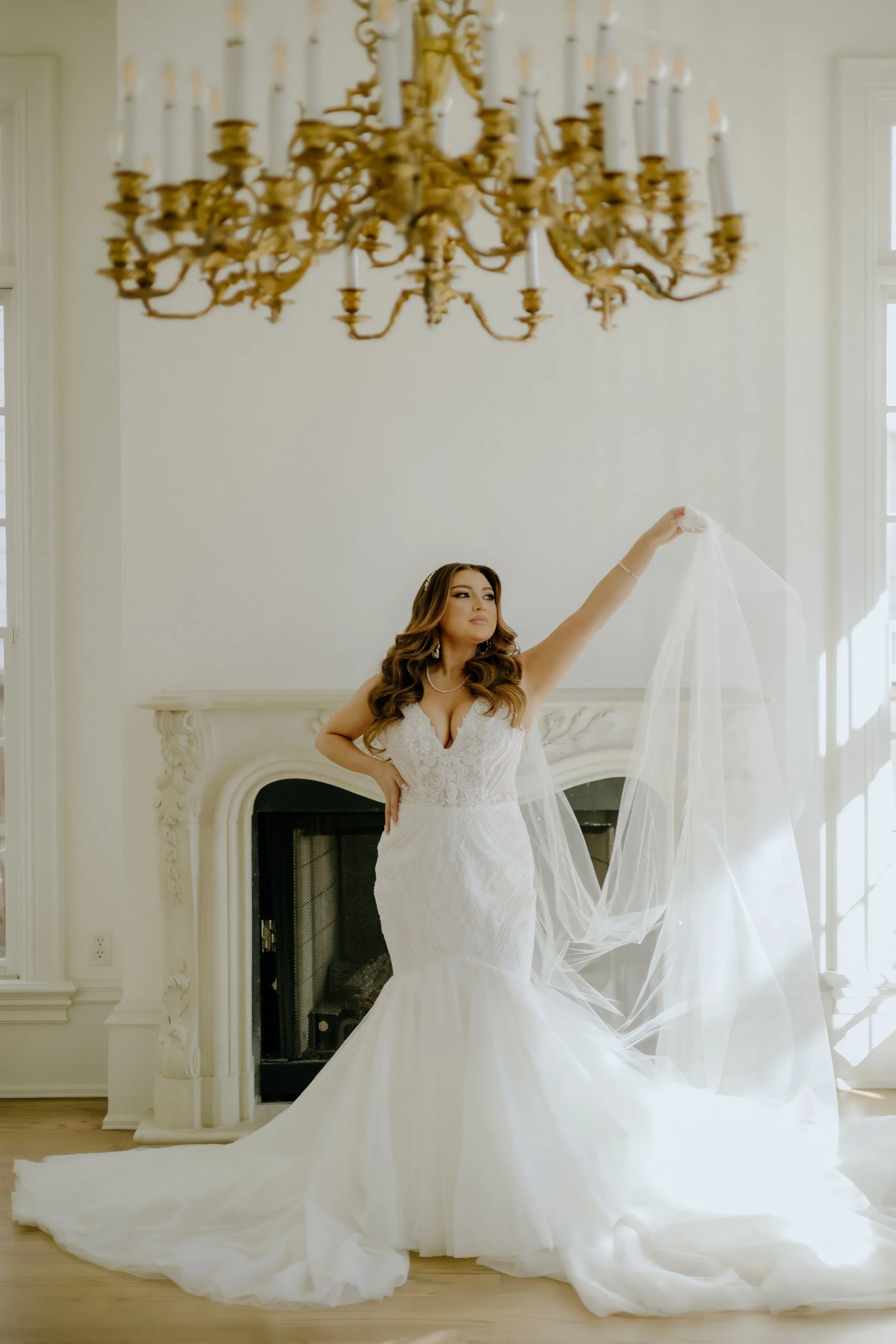 Houston & Texas Family, Couples, Newborn, Maternity, Bridal Photography – Bride posing near chandelier with veil flowing, Houston studio.
