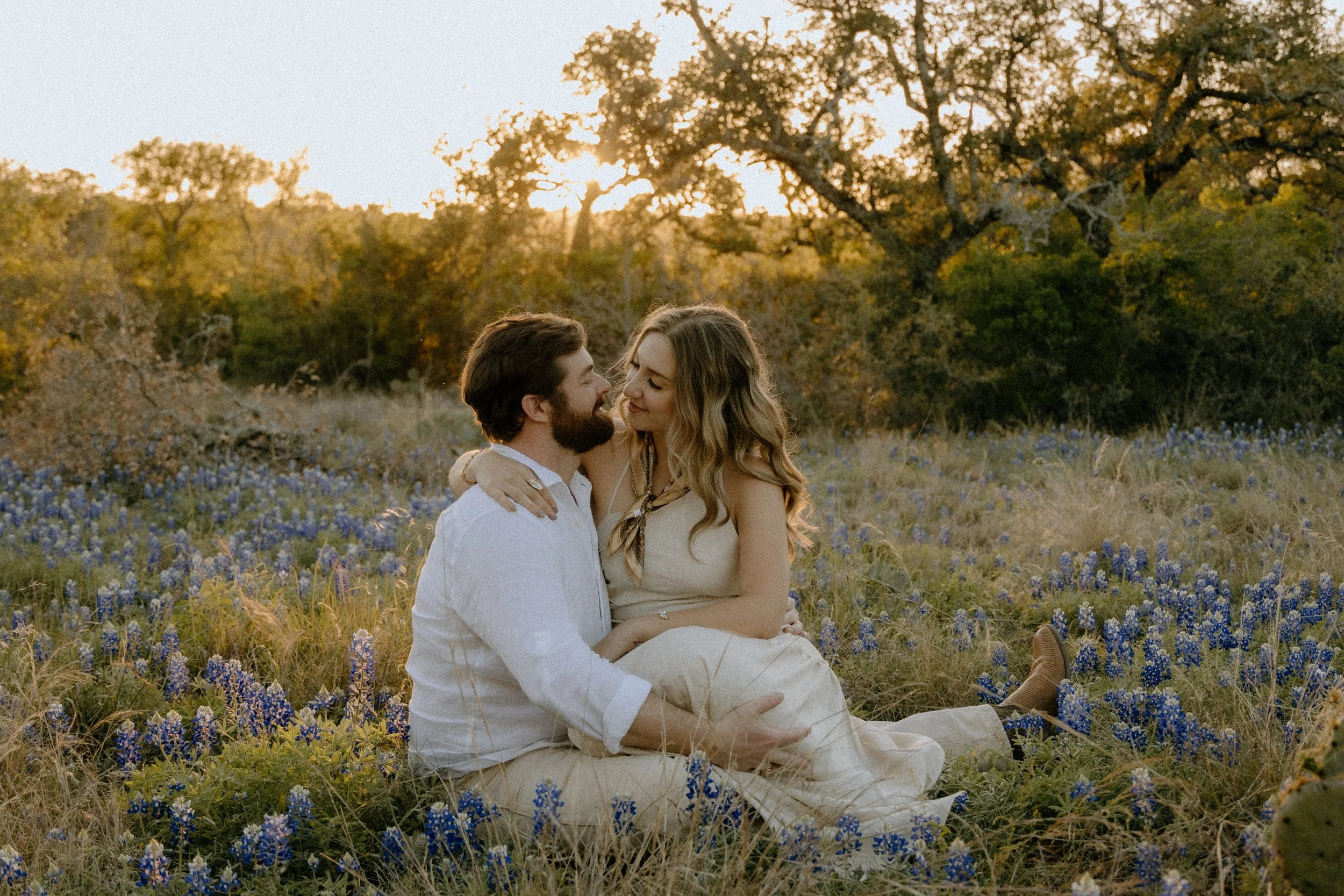 Houston & Texas Family, Couples, Newborn, Maternity, Bridal Photography – Couple seated together in wildflowers, Austin TX sunset portraits.