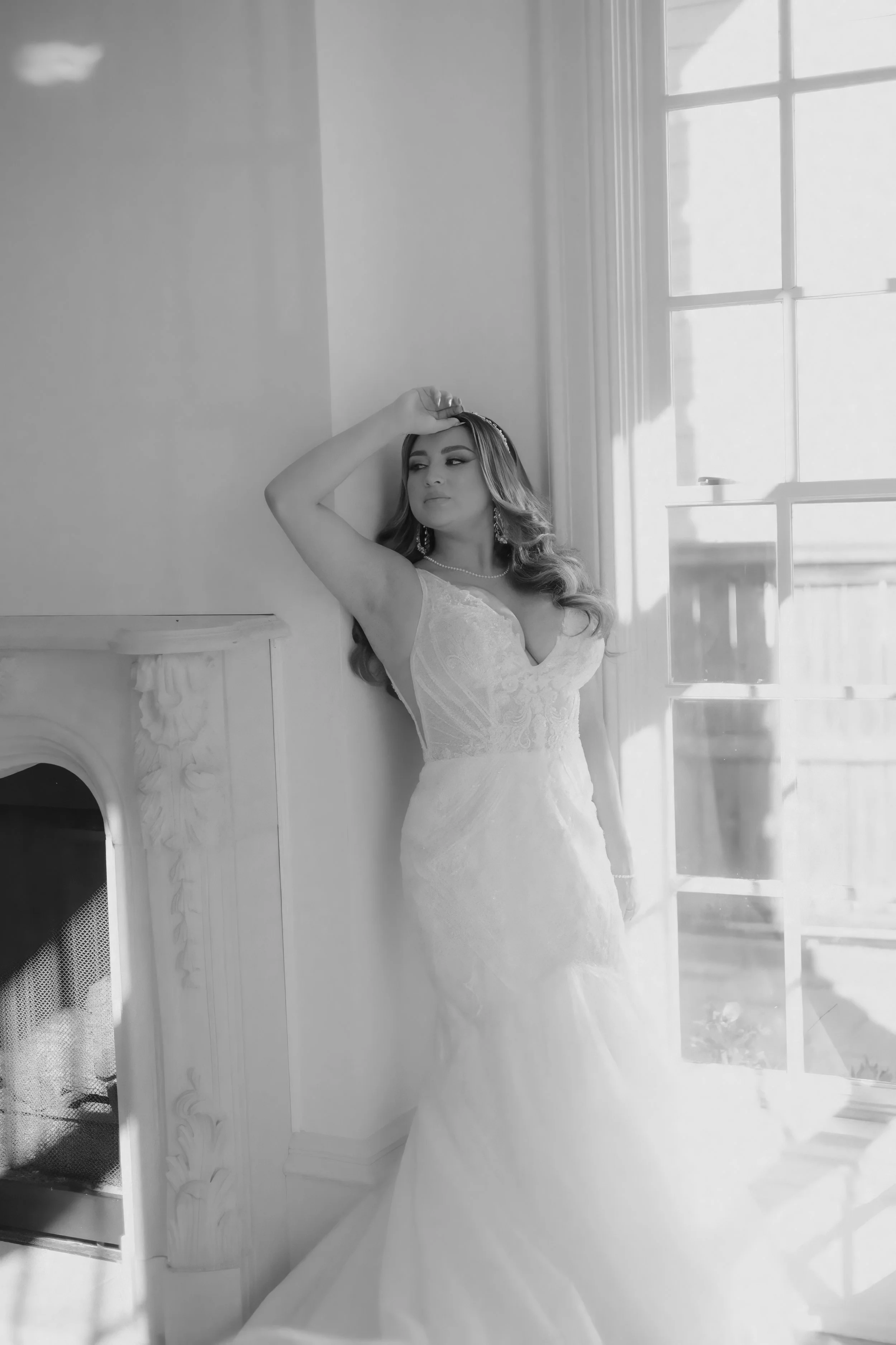 Houston & Texas Family, Couples, Newborn, Maternity, Bridal Photography – Soft black-and-white portrait of bride leaning against fireplace, Houston.