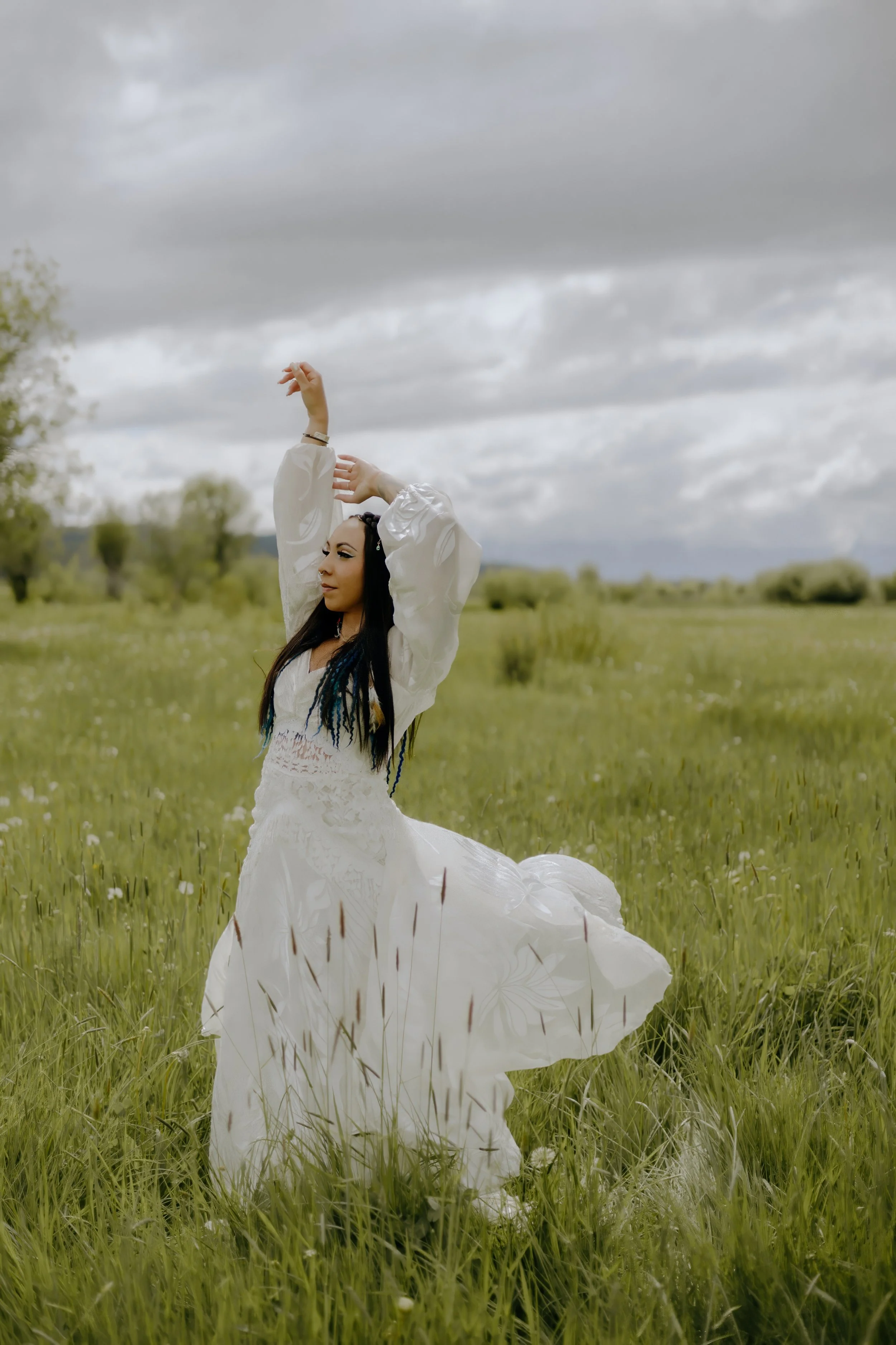 Houston & Texas Wedding & Elopement Photography – Bride twirling dress in grassy field with mountains at Diamond Cross Ranch.