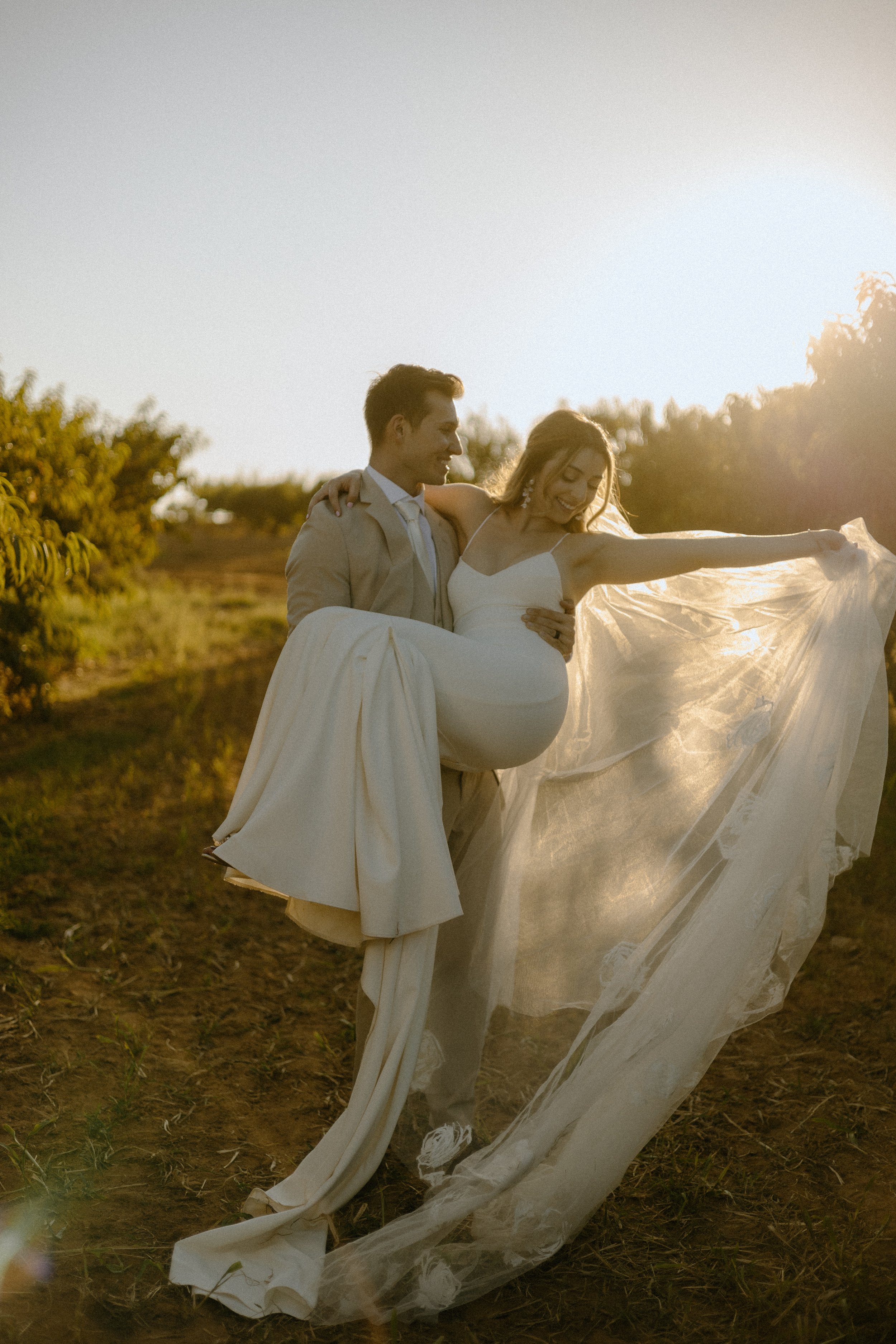 Wedding & Elopement Photography, couple walking on hillside with groom carrying the bride